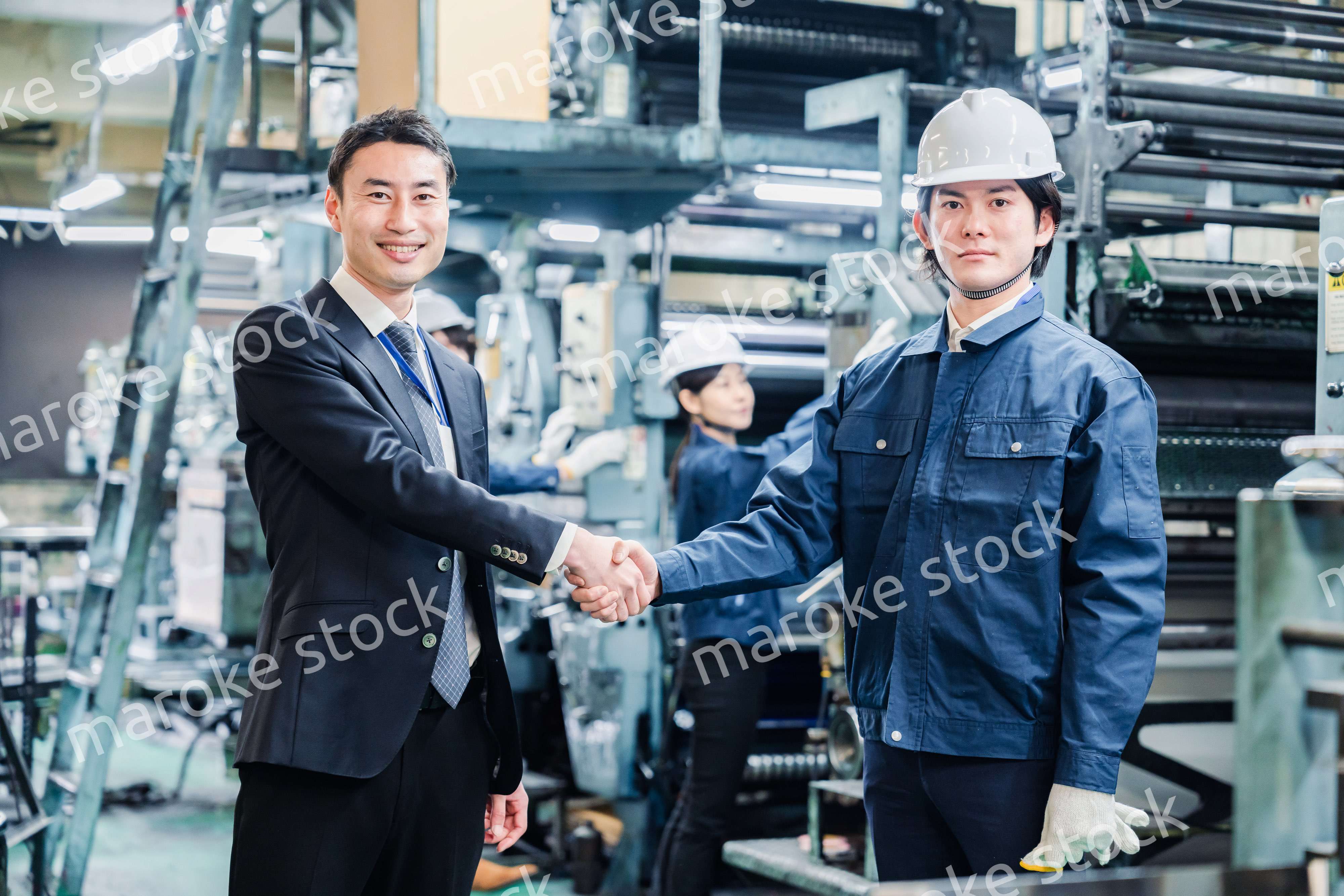 取引先と握手をする工場のスタッフ
