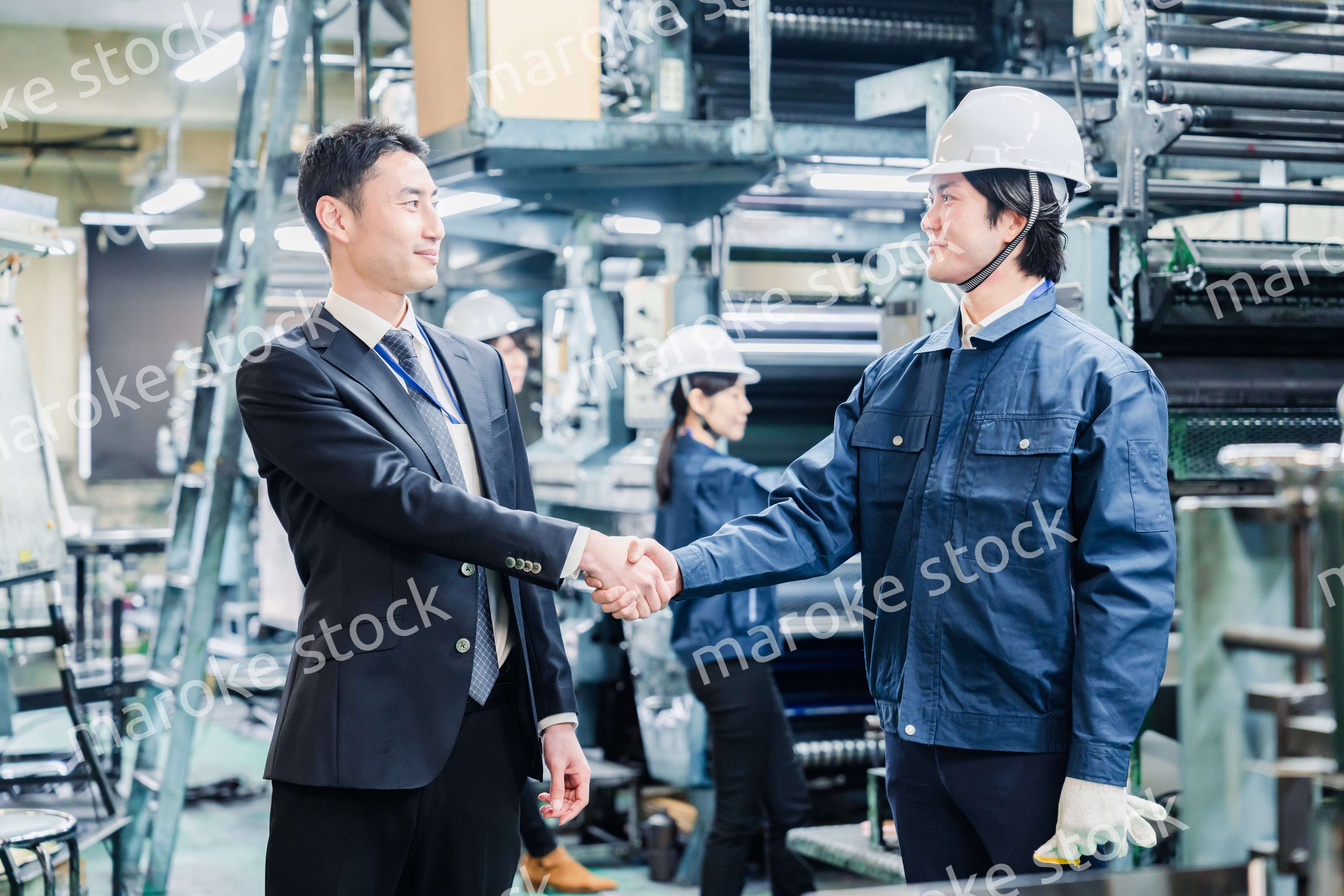 取引先と握手をする工場のスタッフ