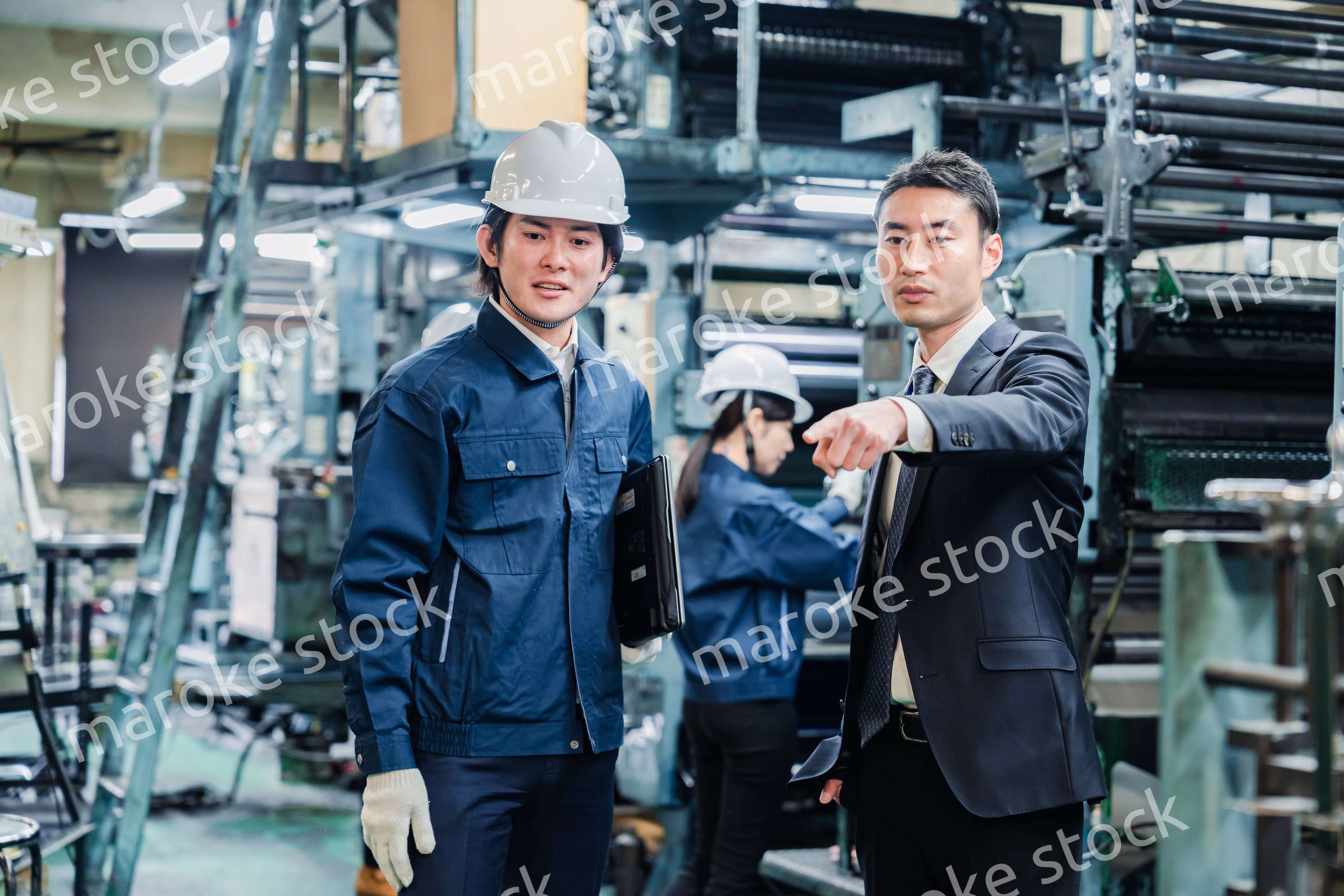 工場を視察するビジネスマン