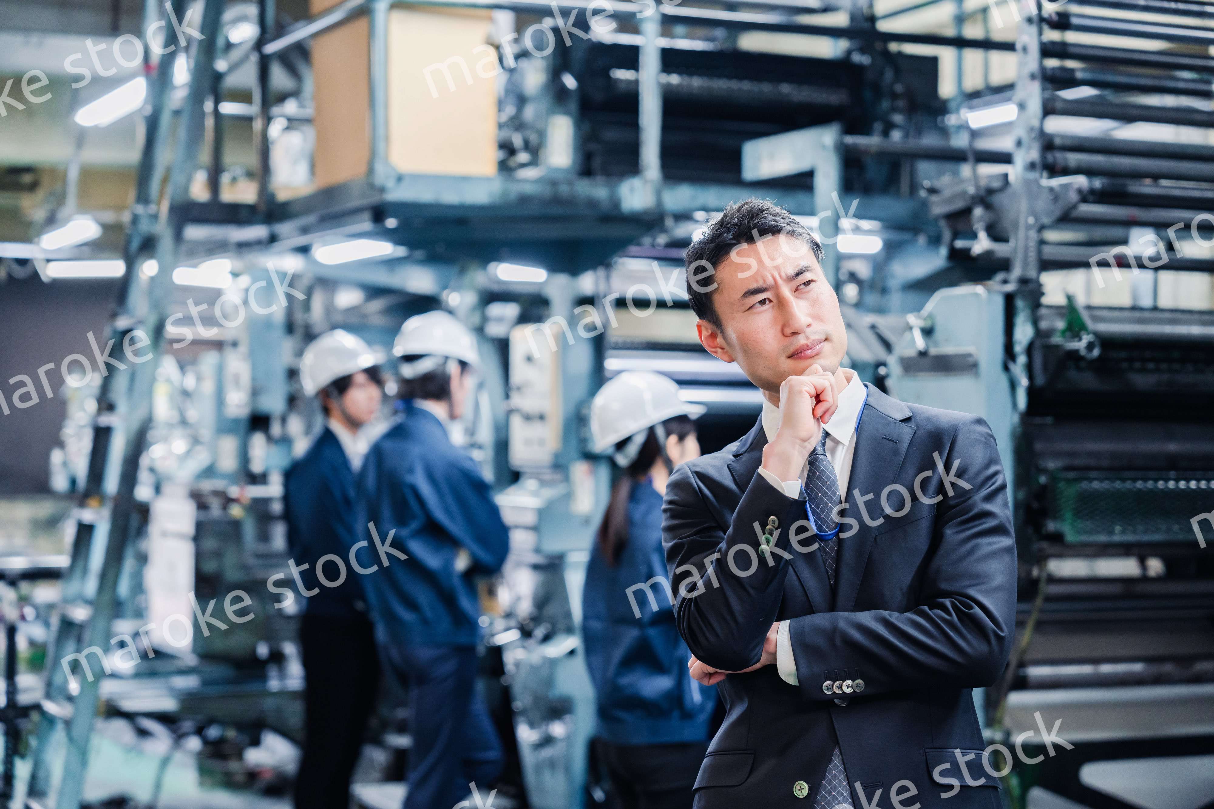 工場で悩むビジネスマン