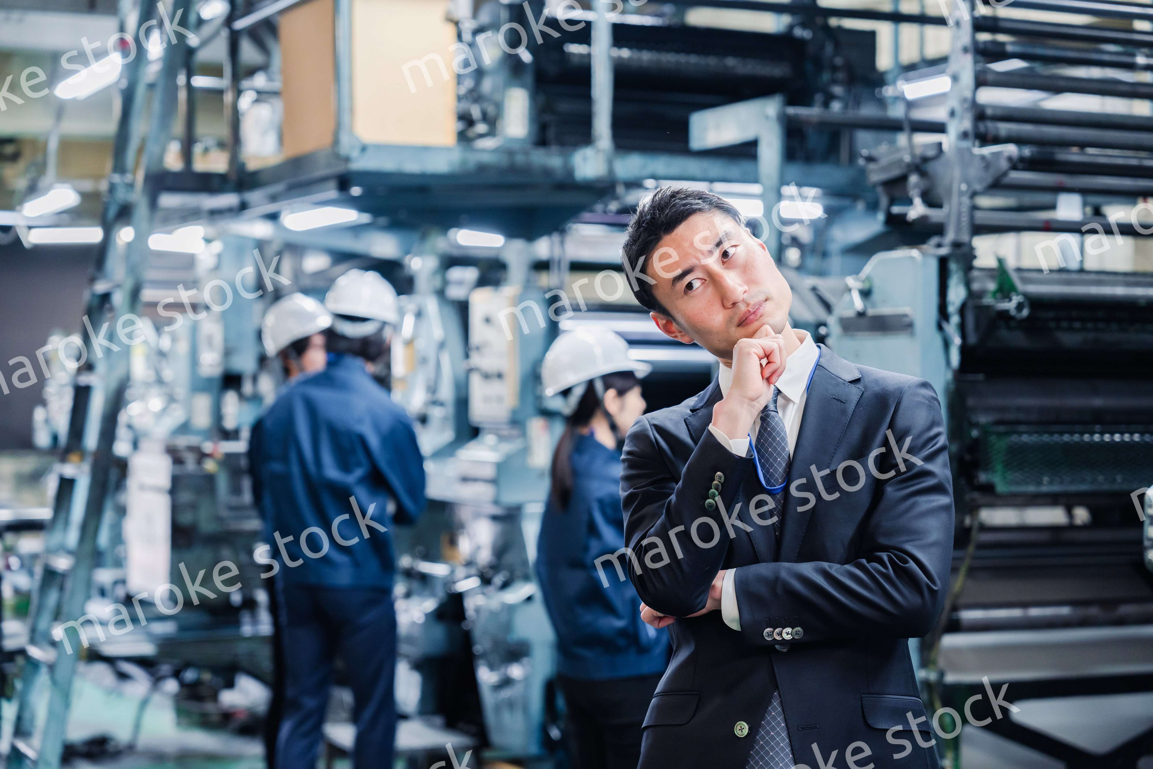 工場で悩むビジネスマン