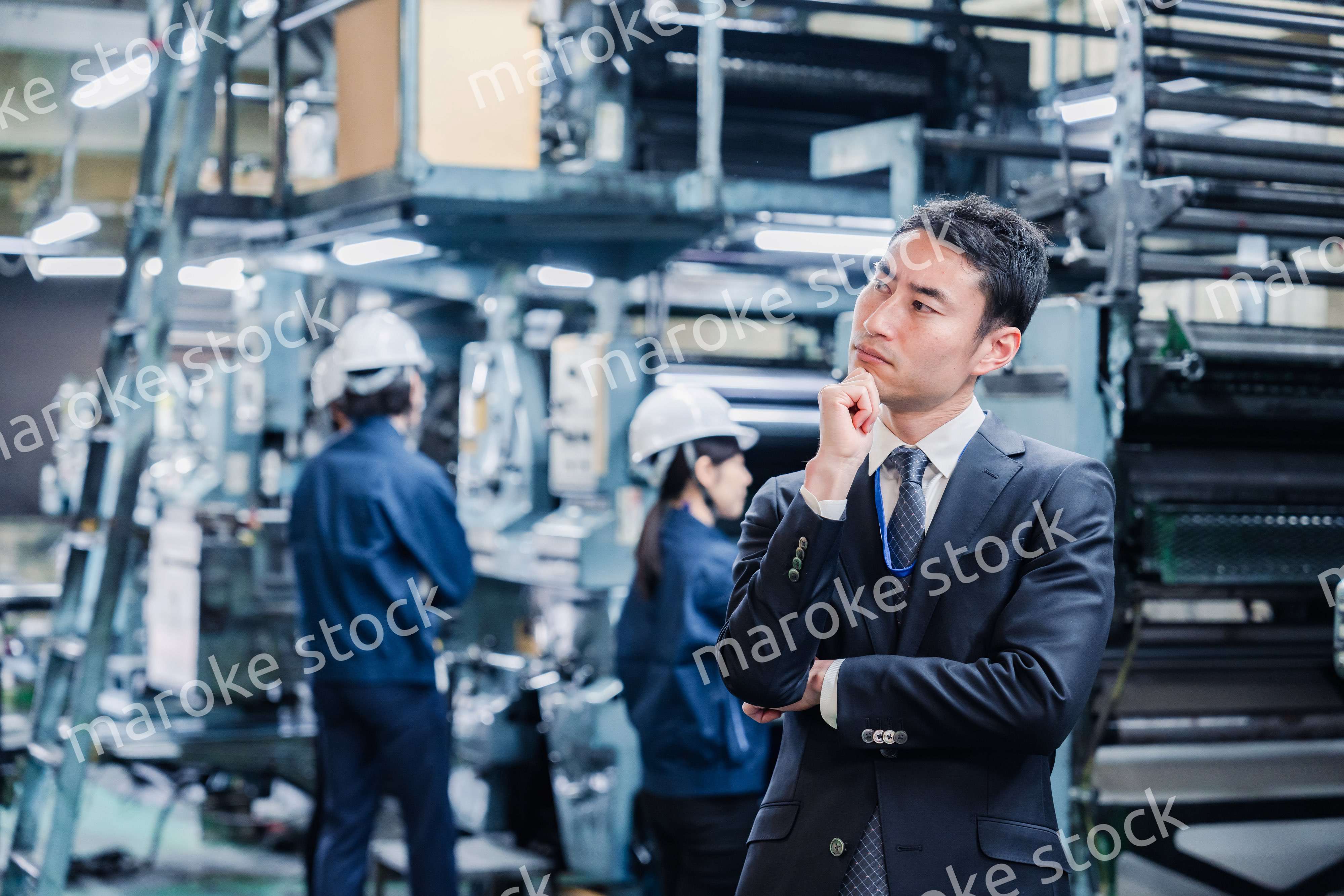 工場で悩むビジネスマン