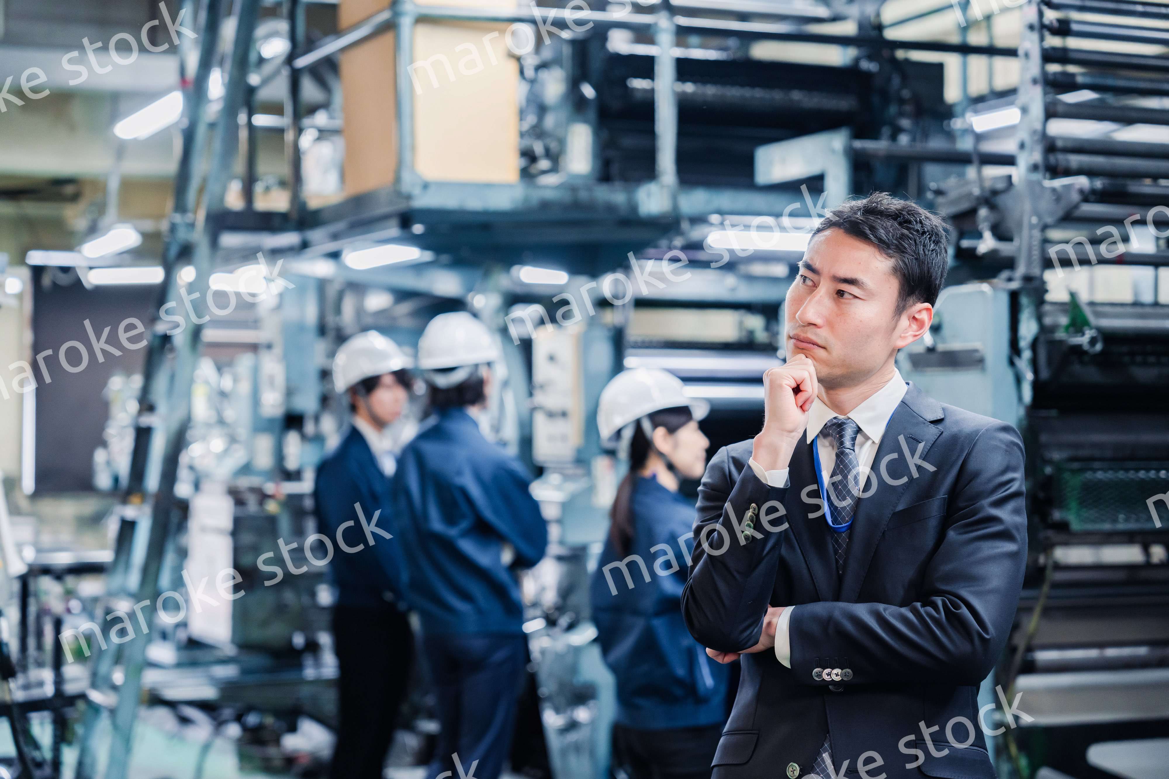 工場で悩むビジネスマン
