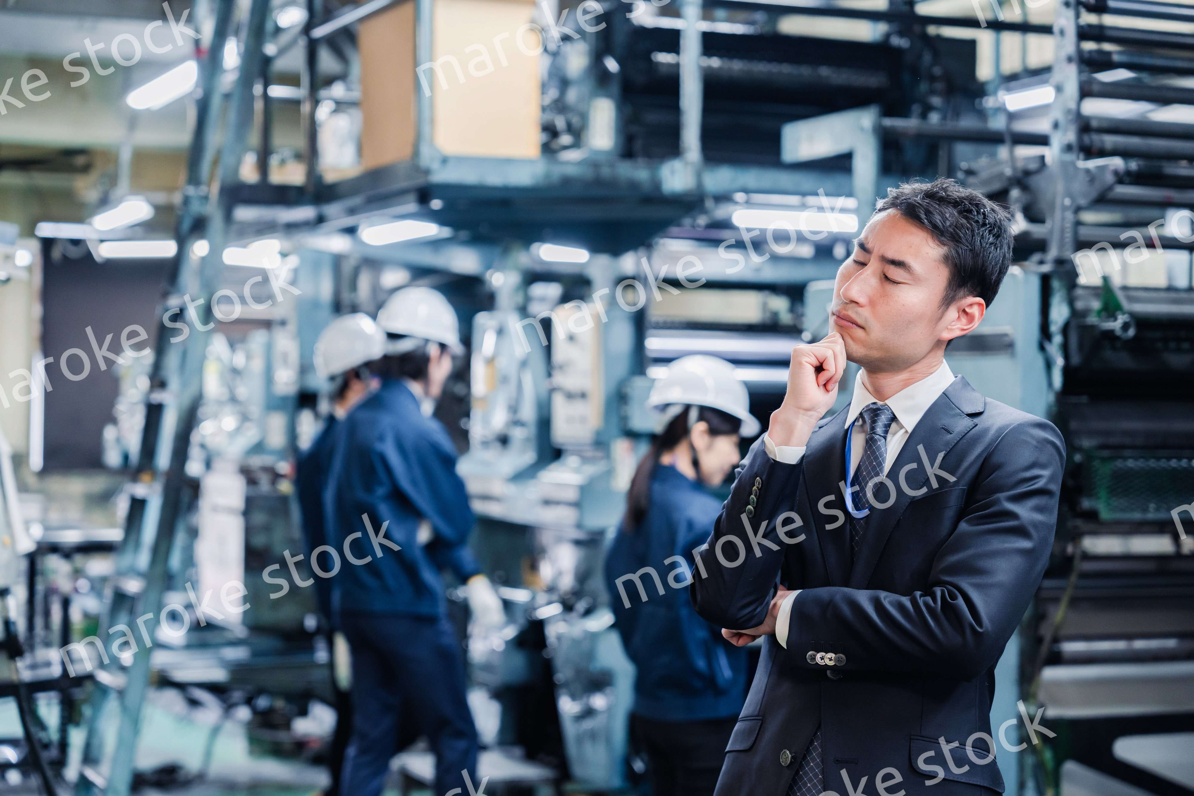 工場で悩むビジネスマン