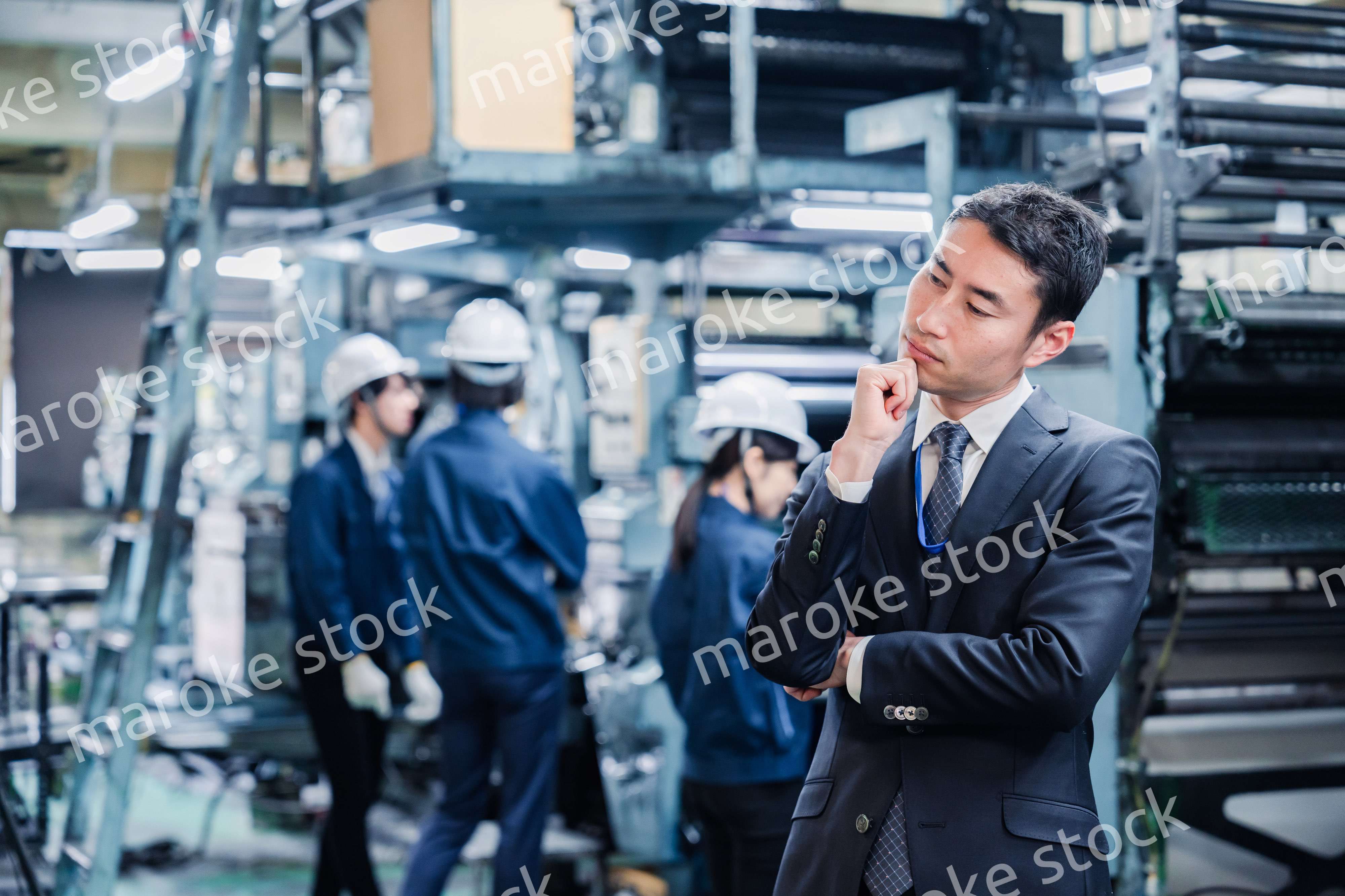 工場で悩むビジネスマン