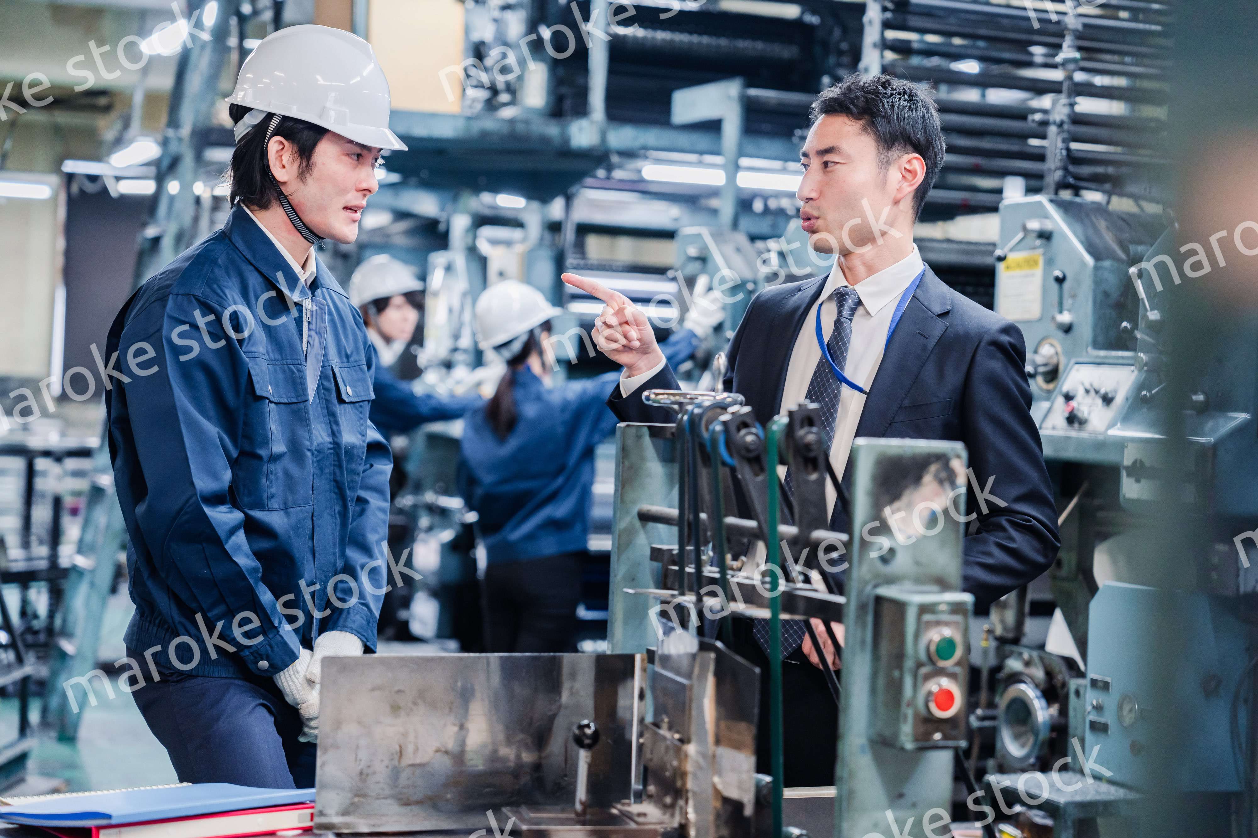 工場の作業員に注意をする経営者