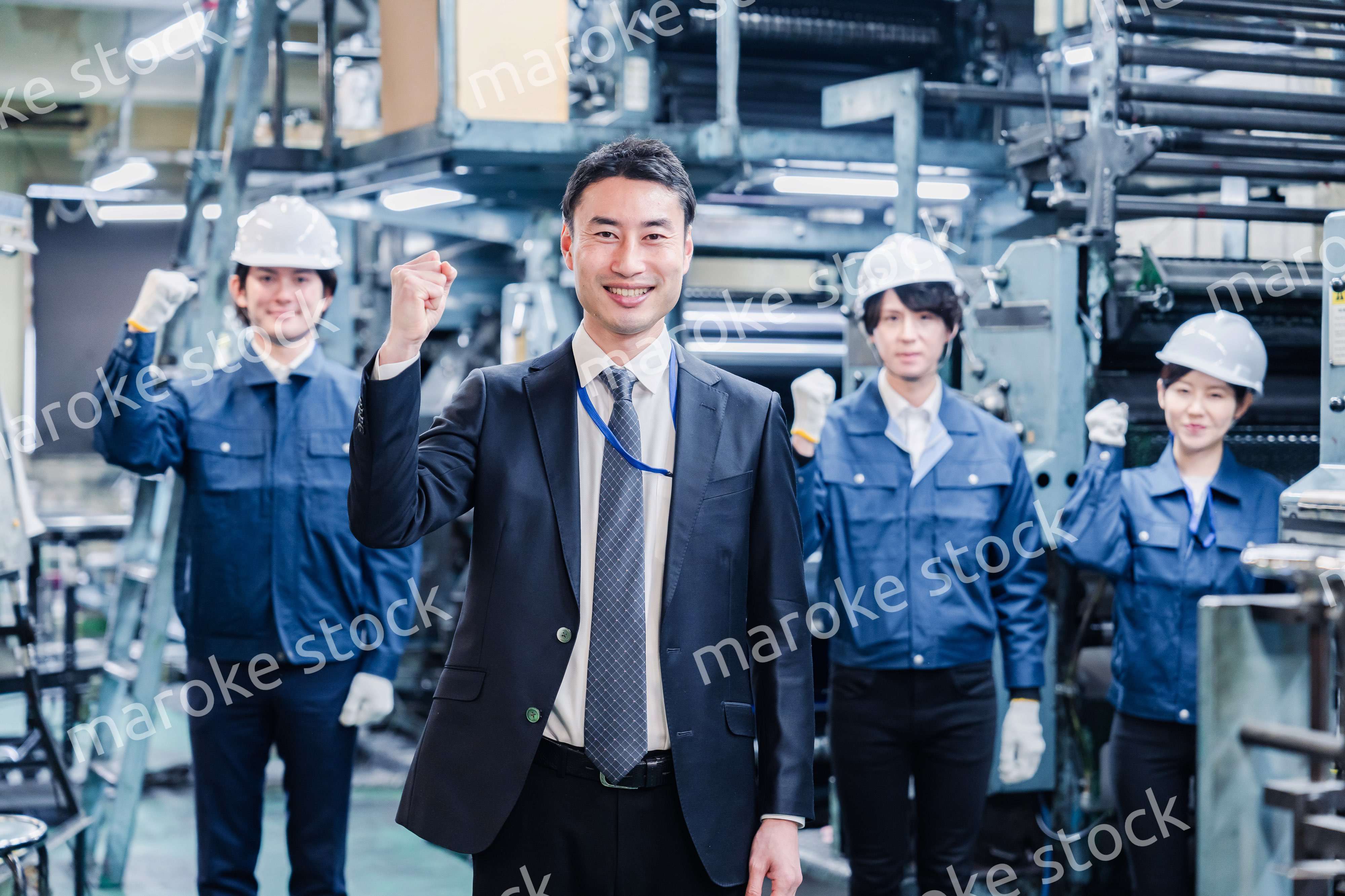 工場でガッツポーズをするスタッフたち