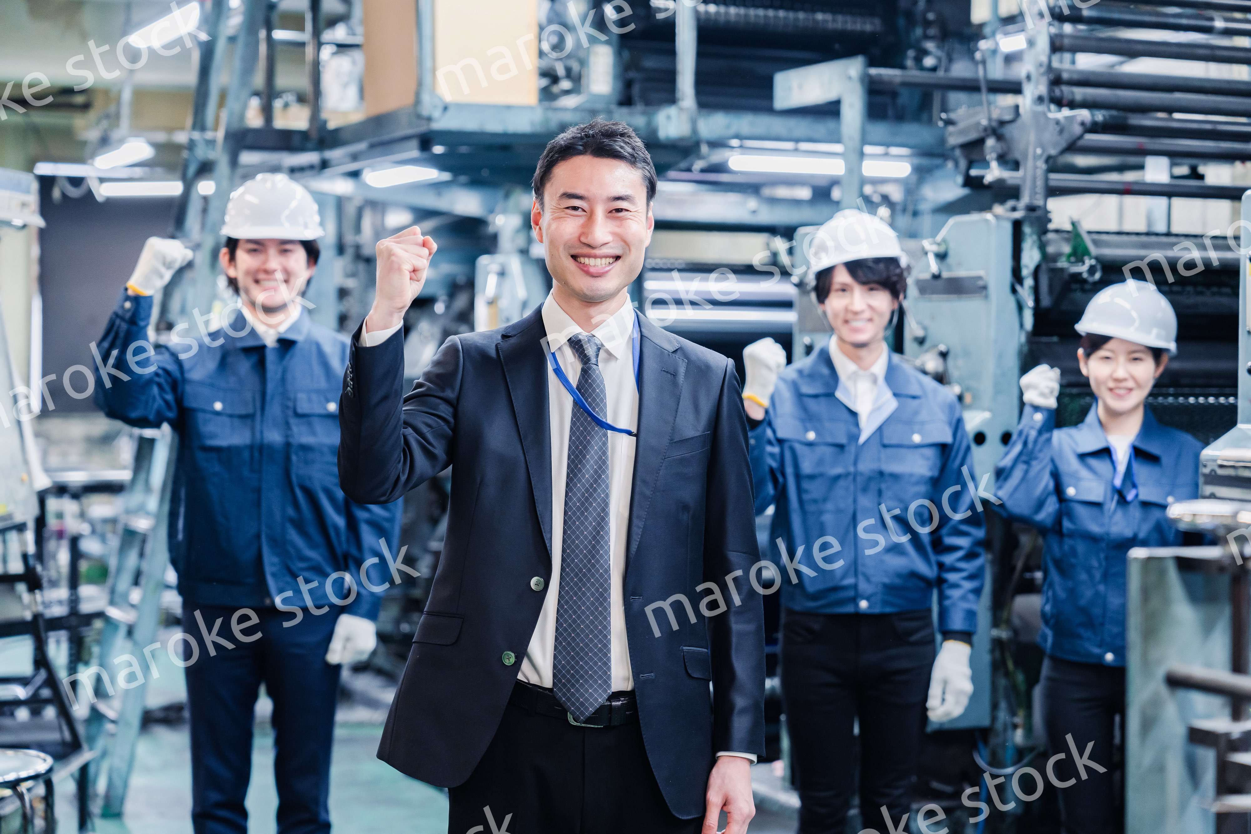 工場でガッツポーズをするスタッフたち