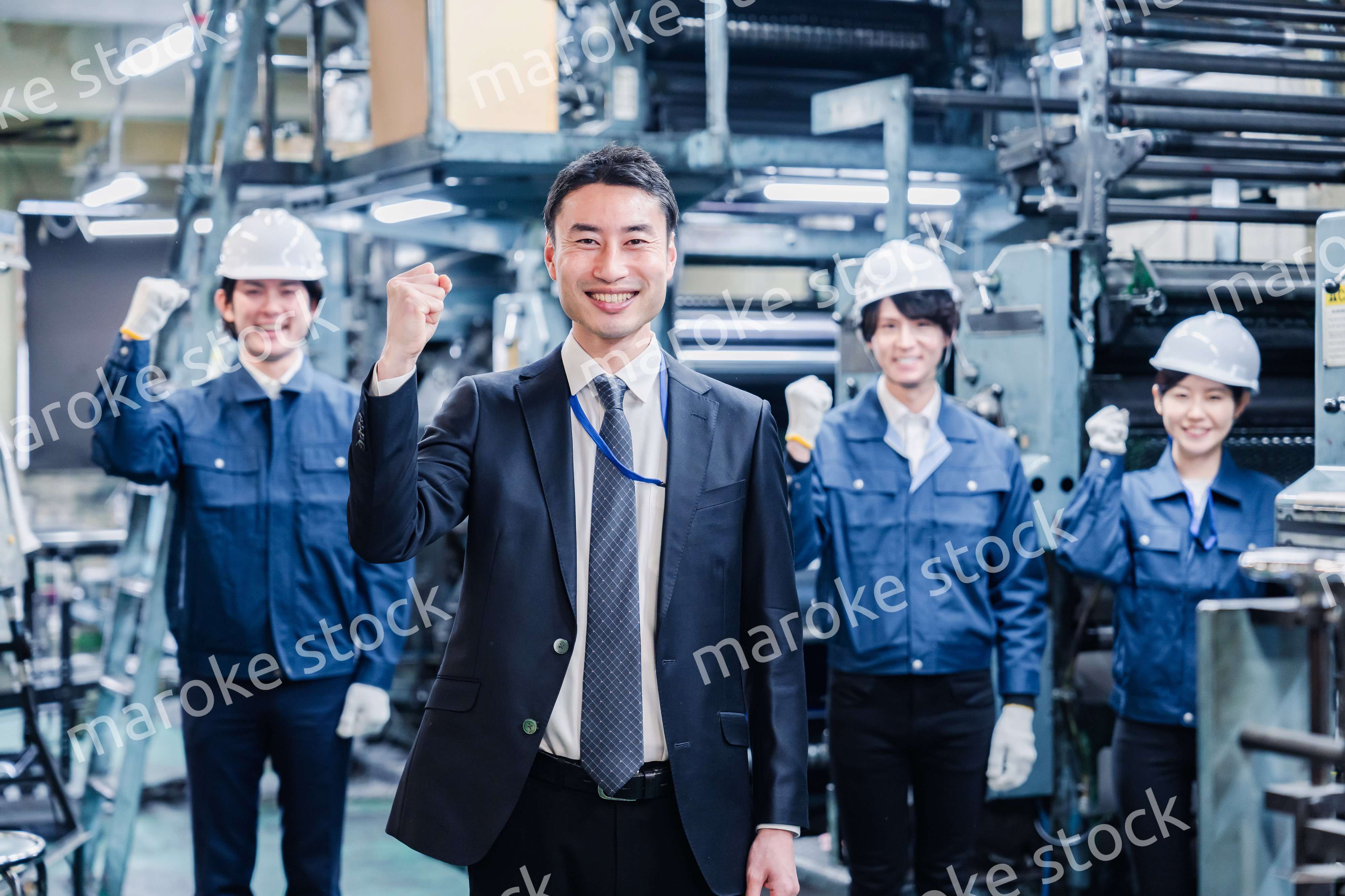 工場でガッツポーズをするスタッフたち