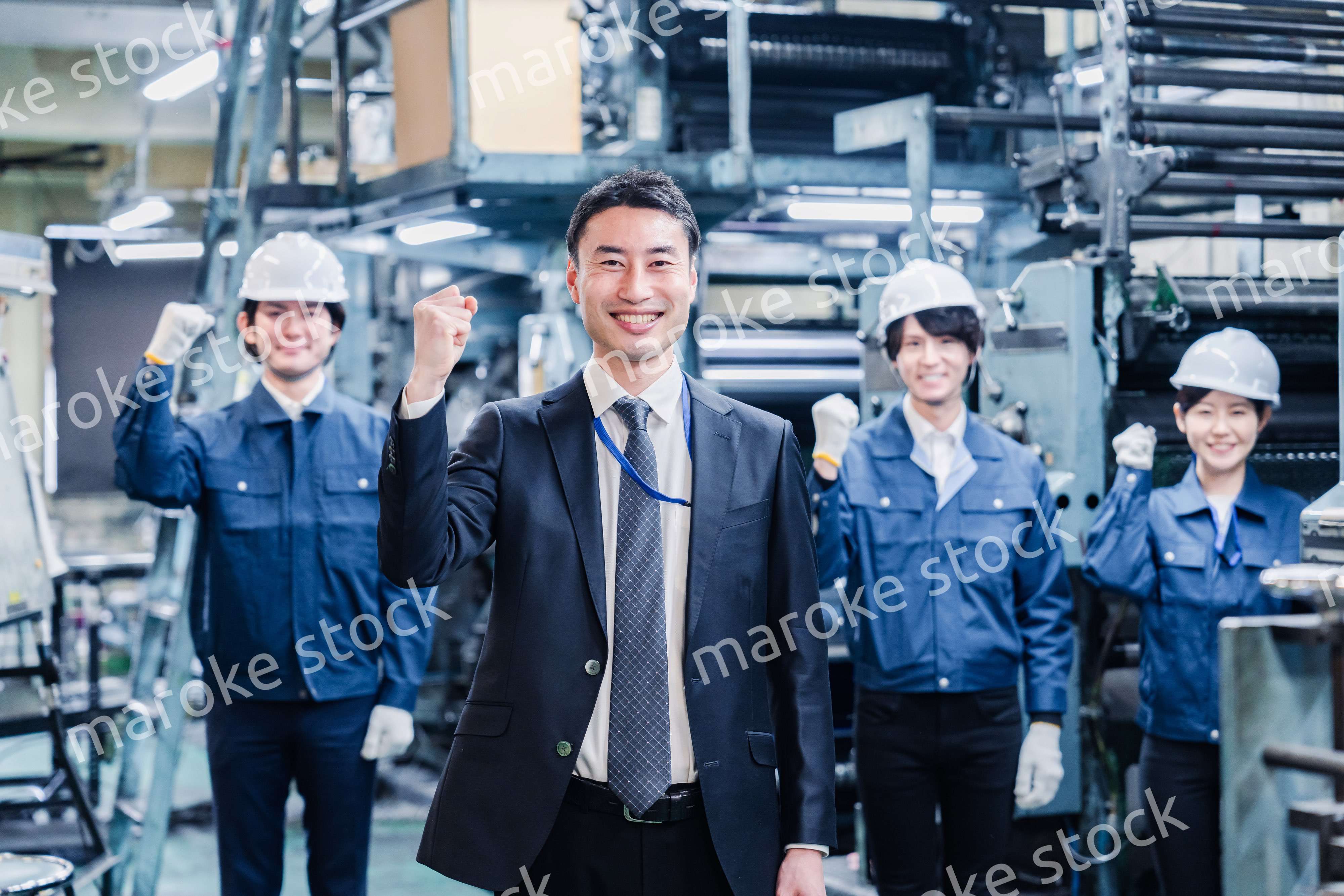 工場でガッツポーズをするスタッフたち