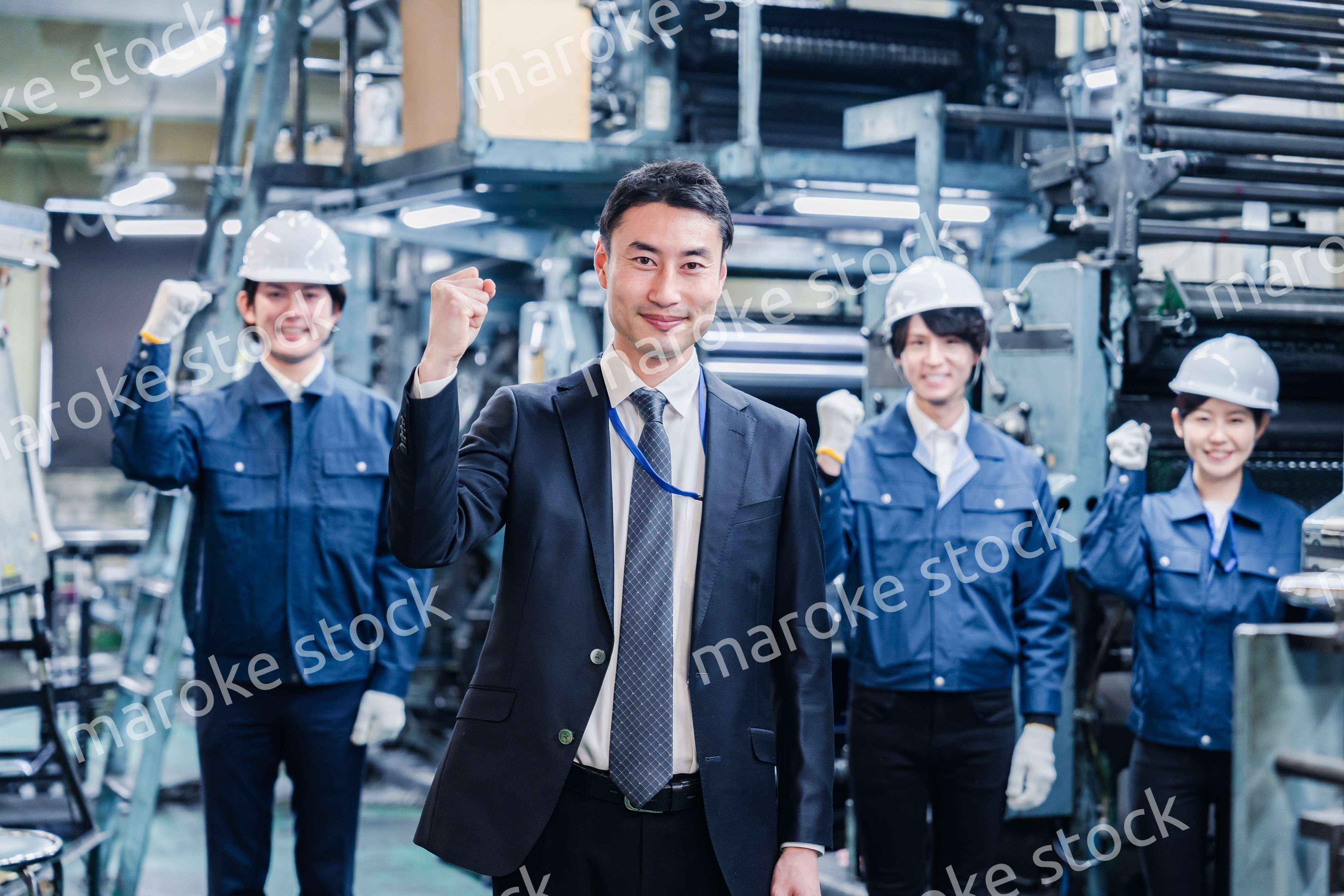 工場でガッツポーズをするスタッフたち