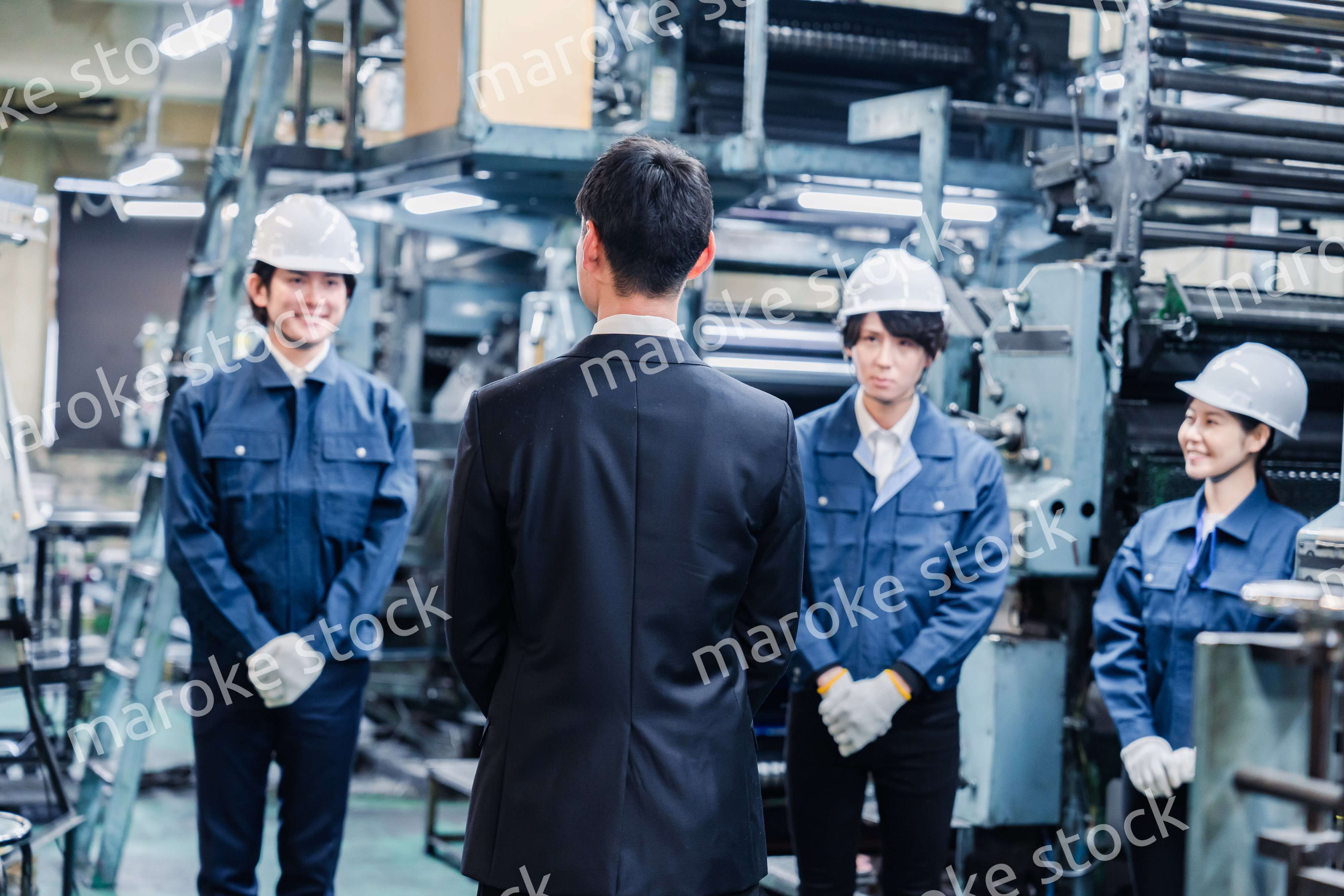 管理職の訓示を聴く工場スタッフ