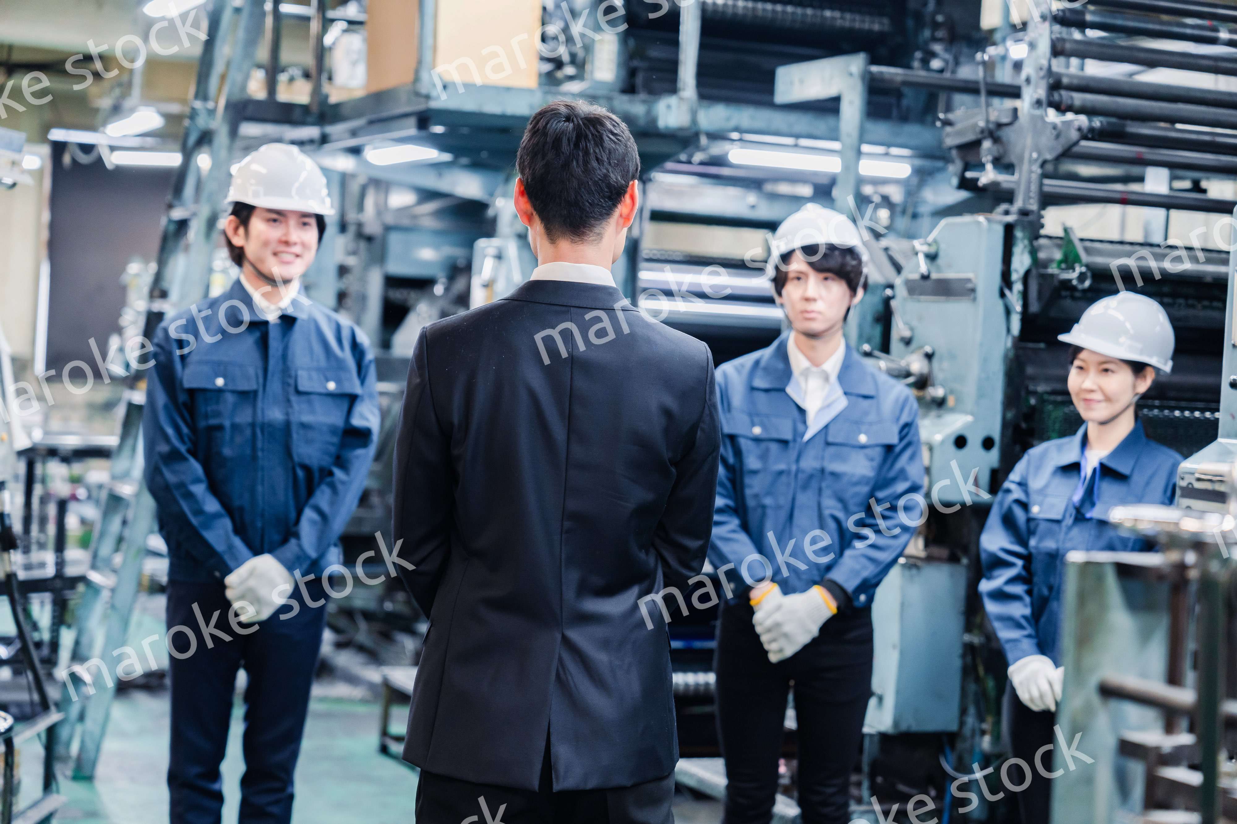 管理職の訓示を聴く工場スタッフ