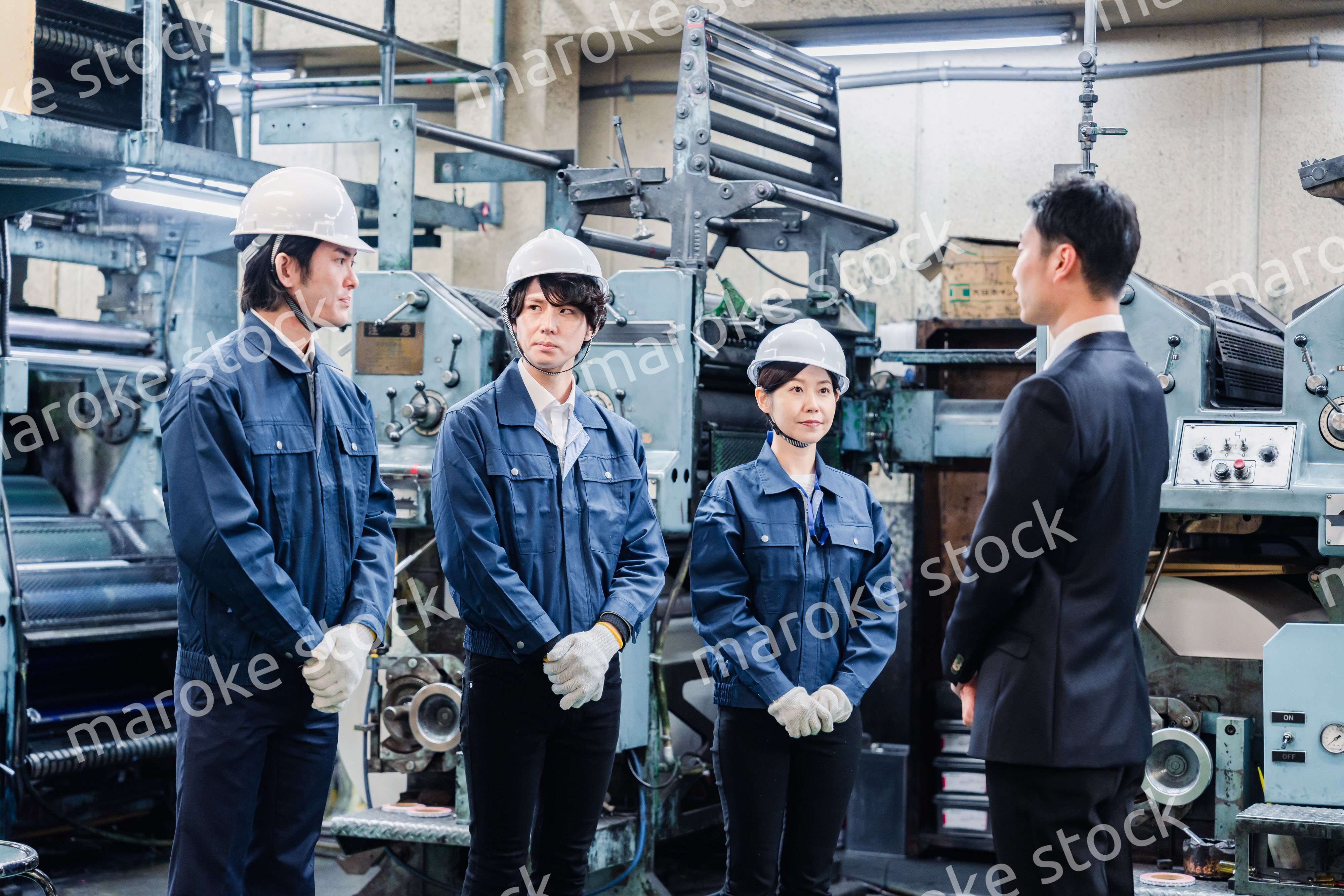 管理職の訓示を聴く工場スタッフ