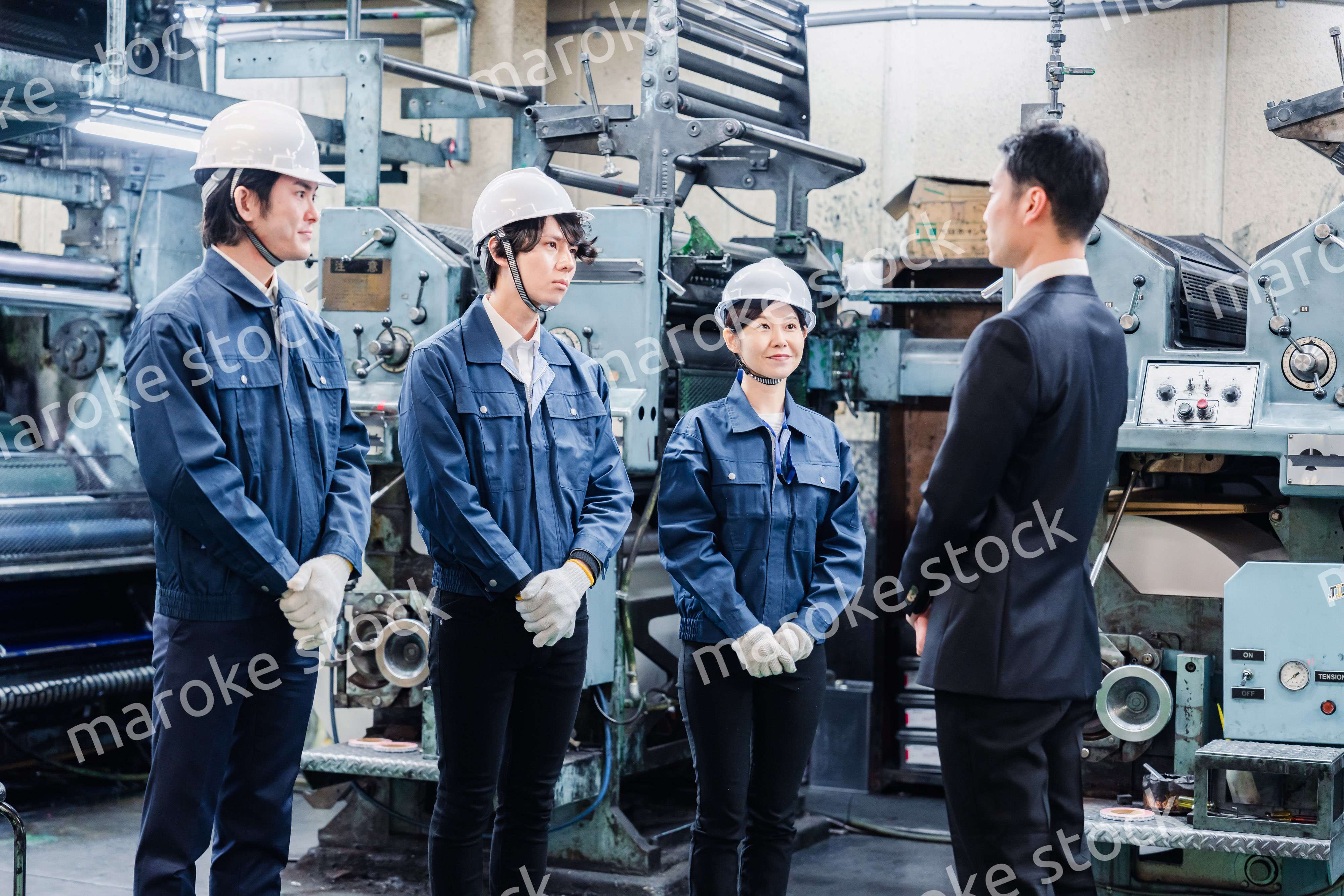 管理職の訓示を聴く工場スタッフ