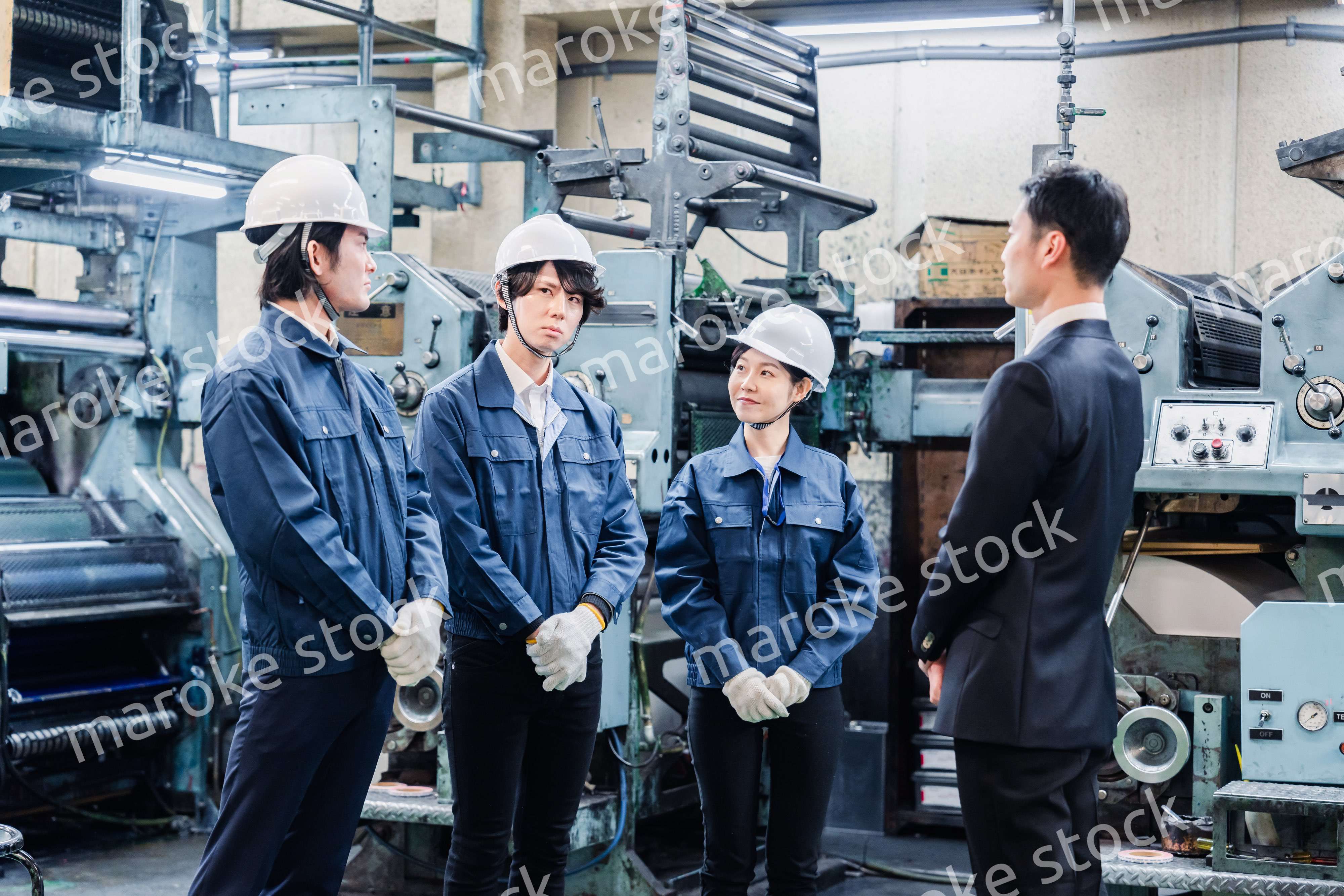 管理職の訓示を聴く工場スタッフ