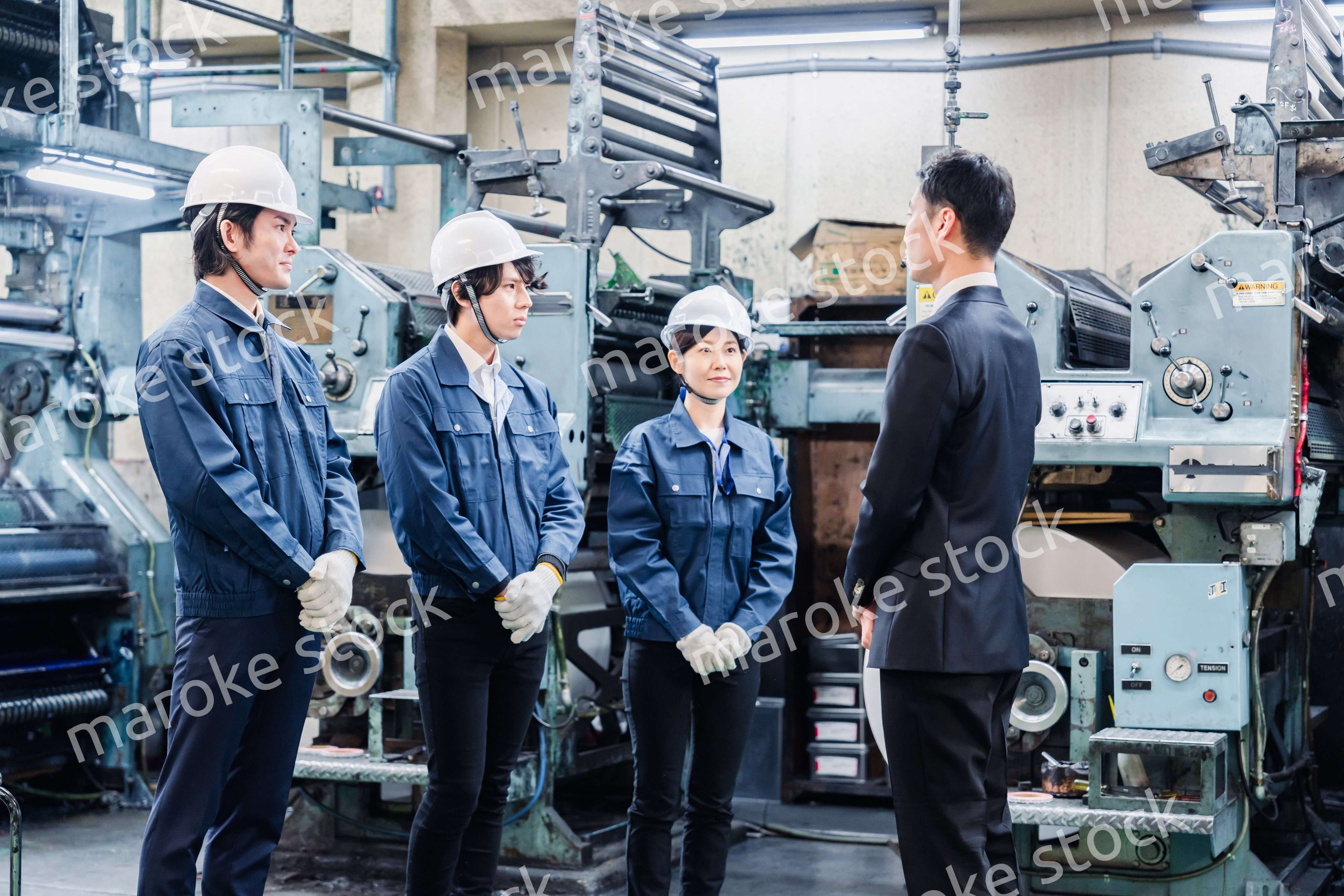 管理職の訓示を聴く工場スタッフ