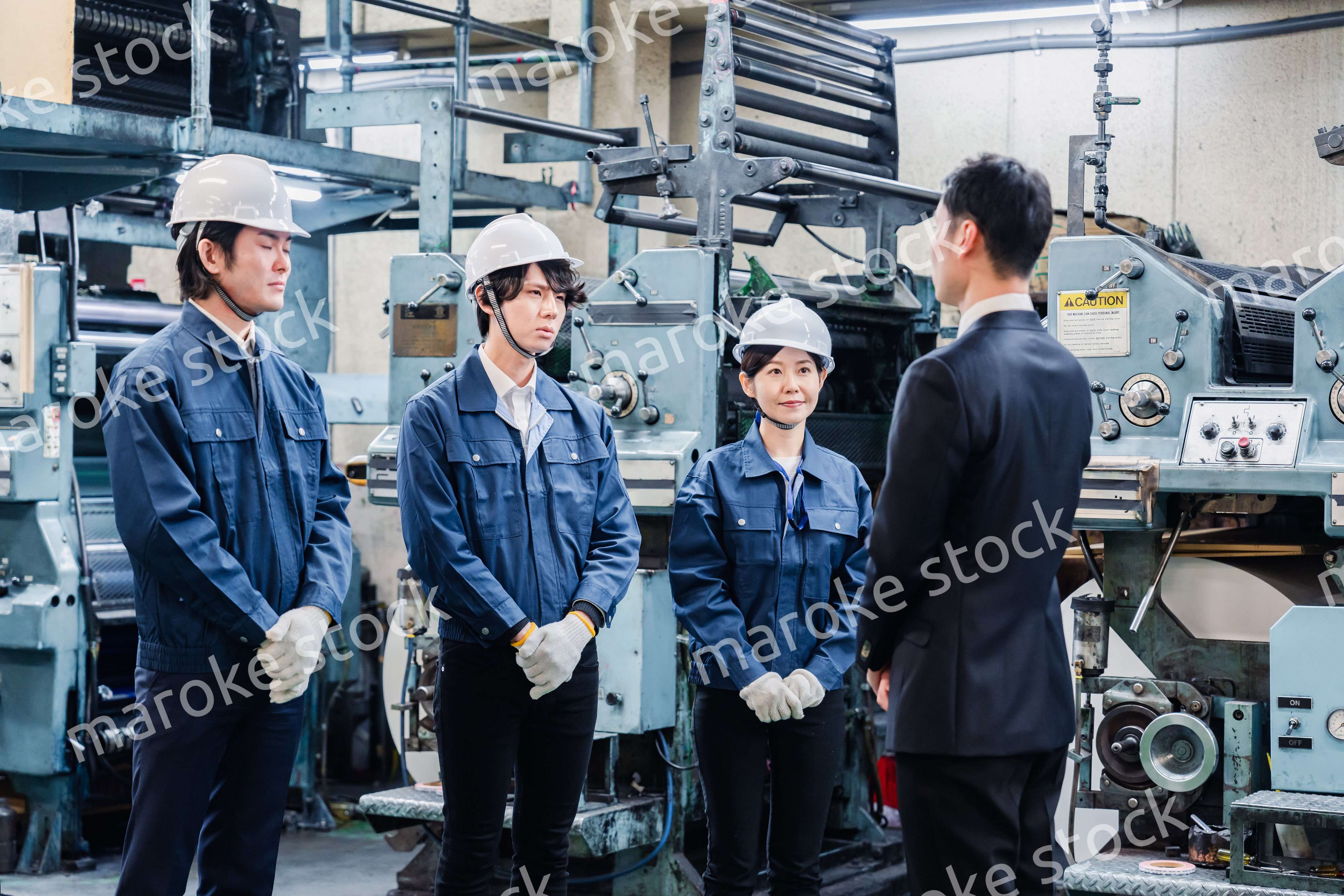 管理職の訓示を聴く工場スタッフ