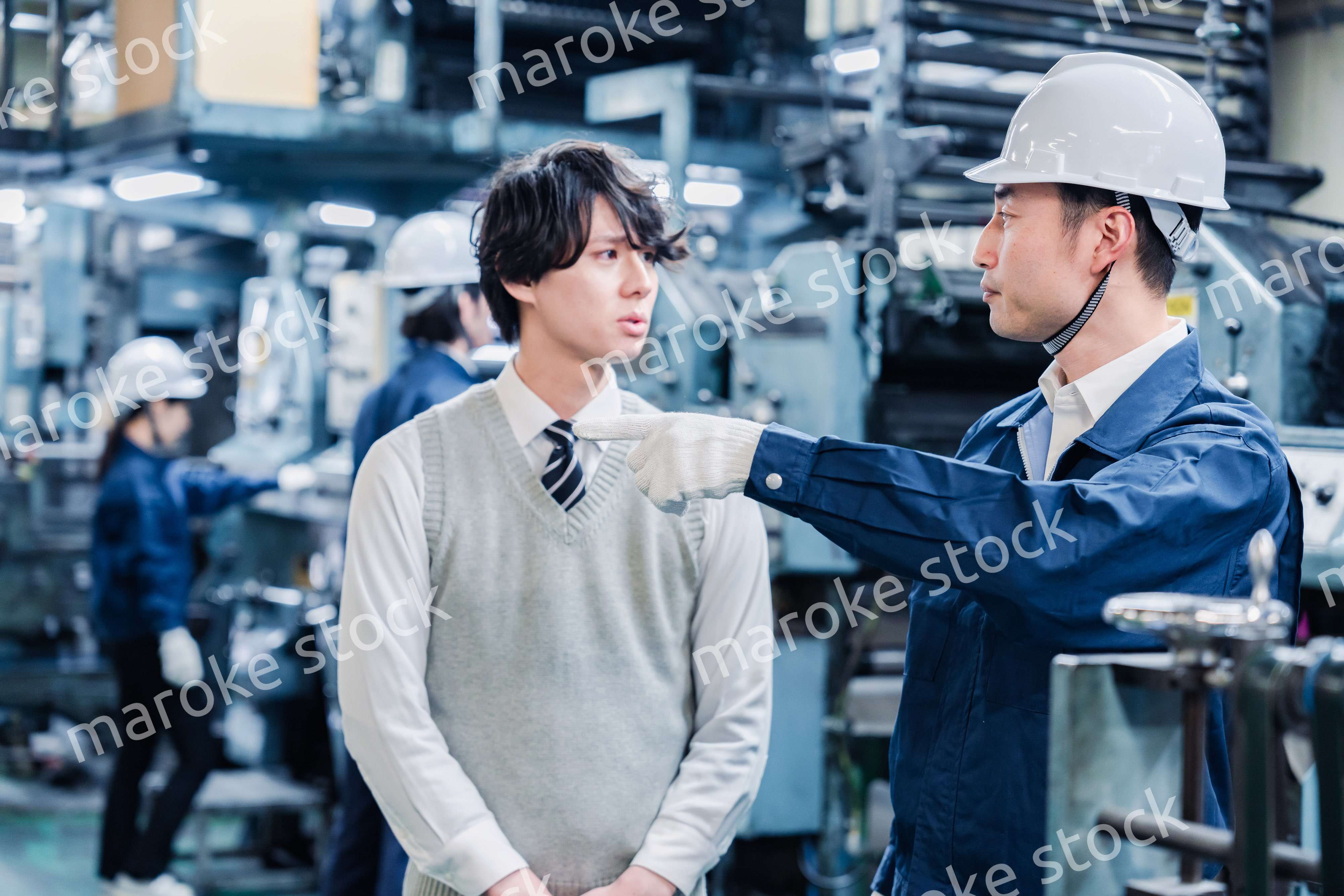 工場を見学する男子学生