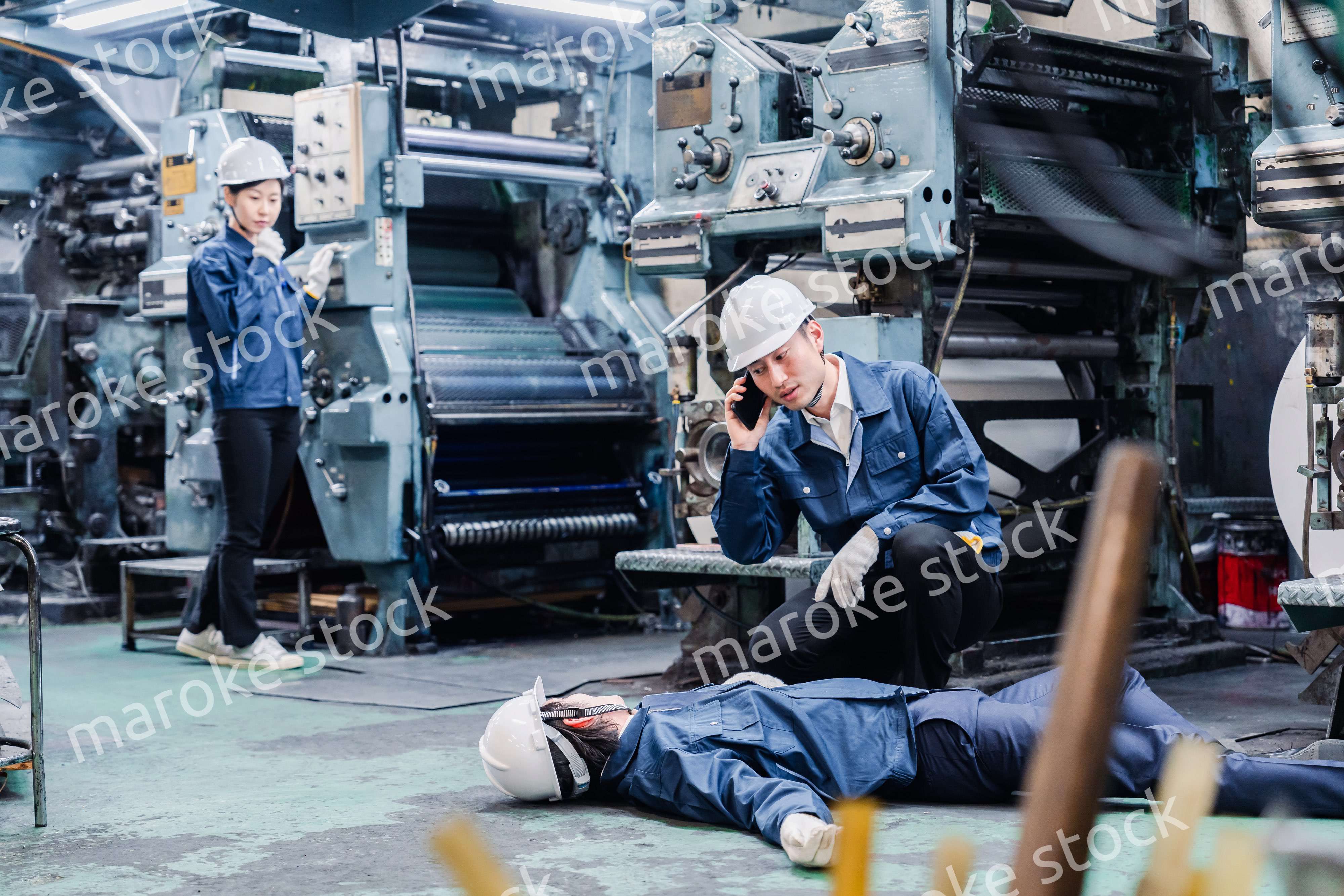 工場で救急通報をする従業員
