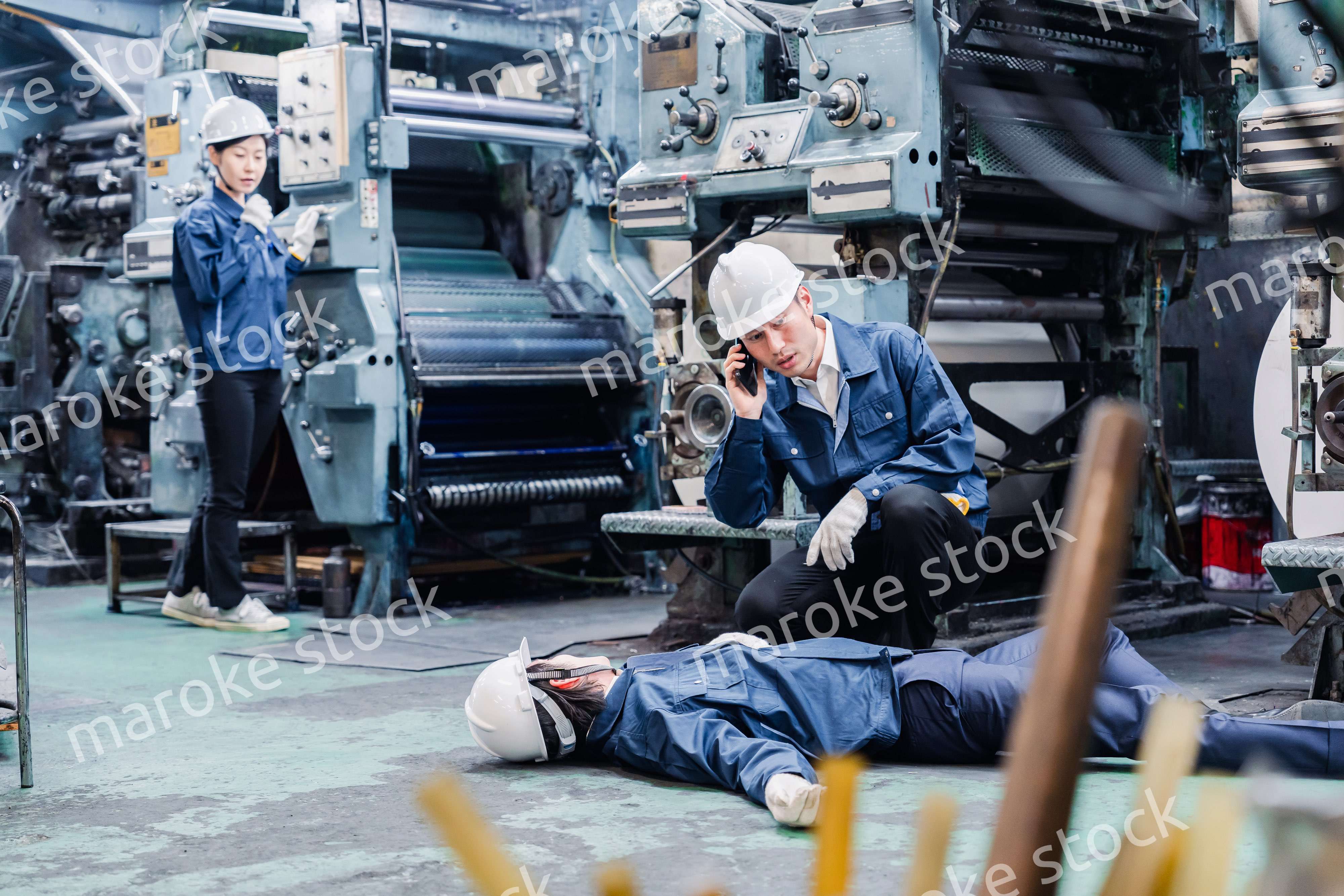 工場で救急通報をする従業員