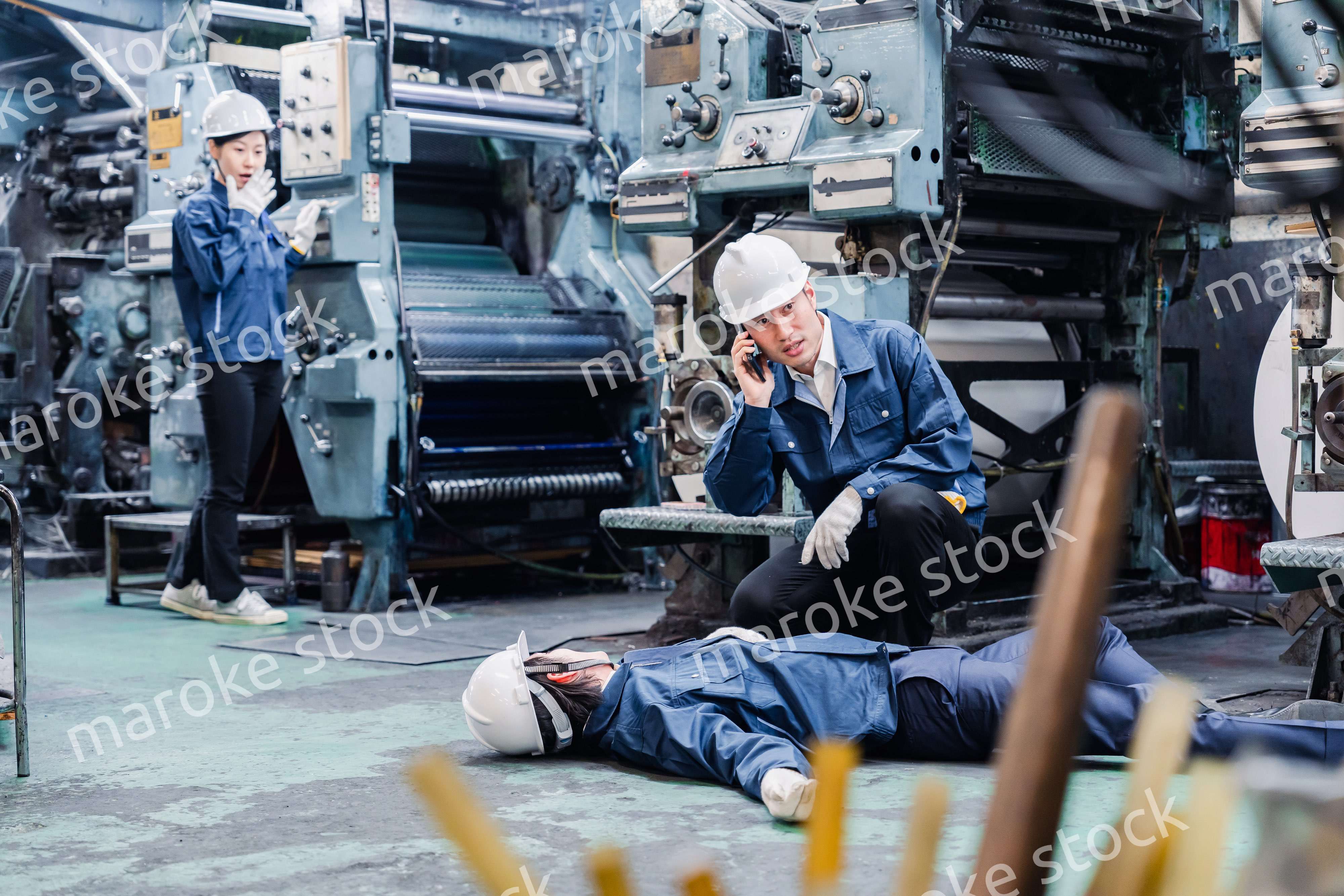 工場で救急通報をする従業員