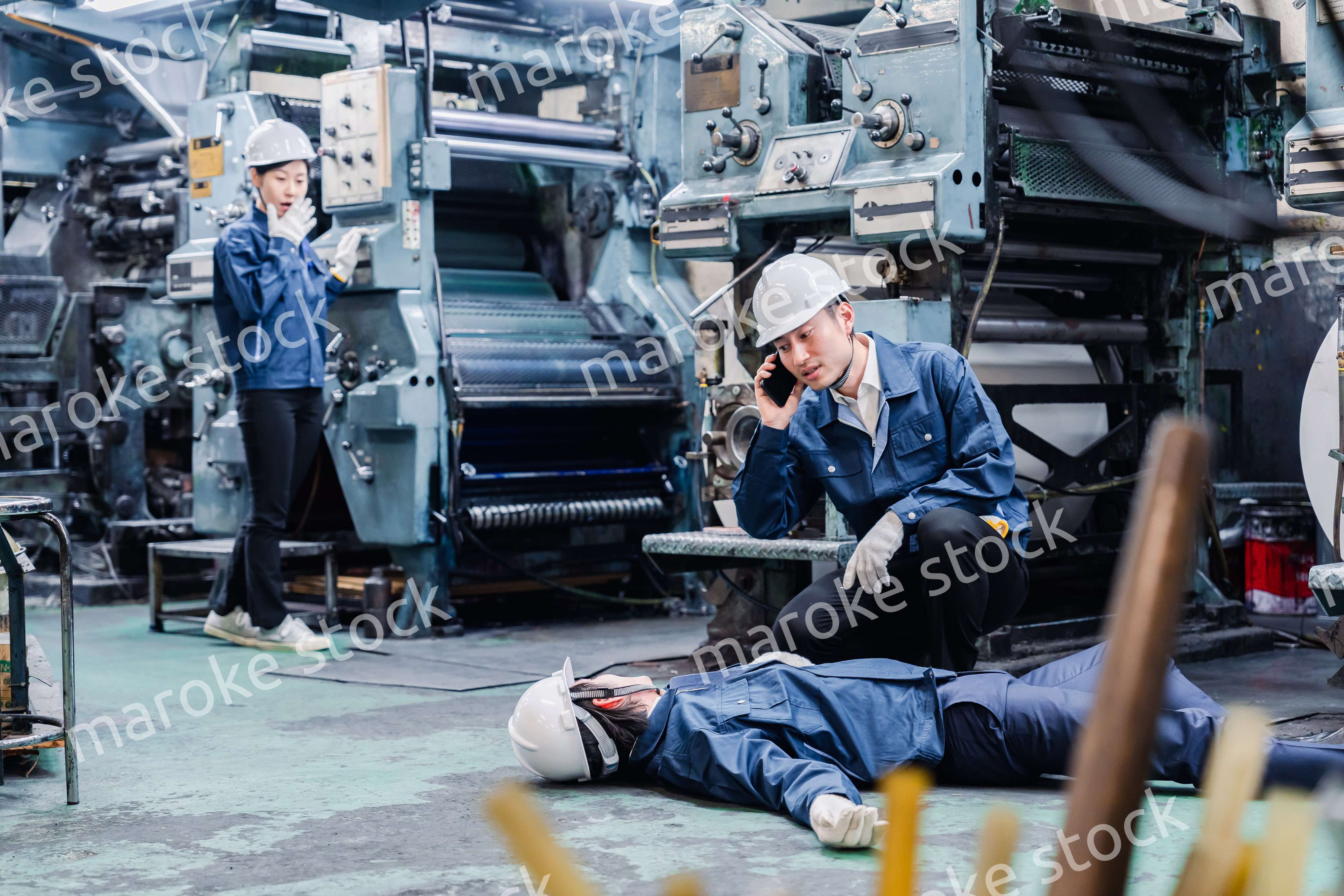 工場で救急通報をする従業員