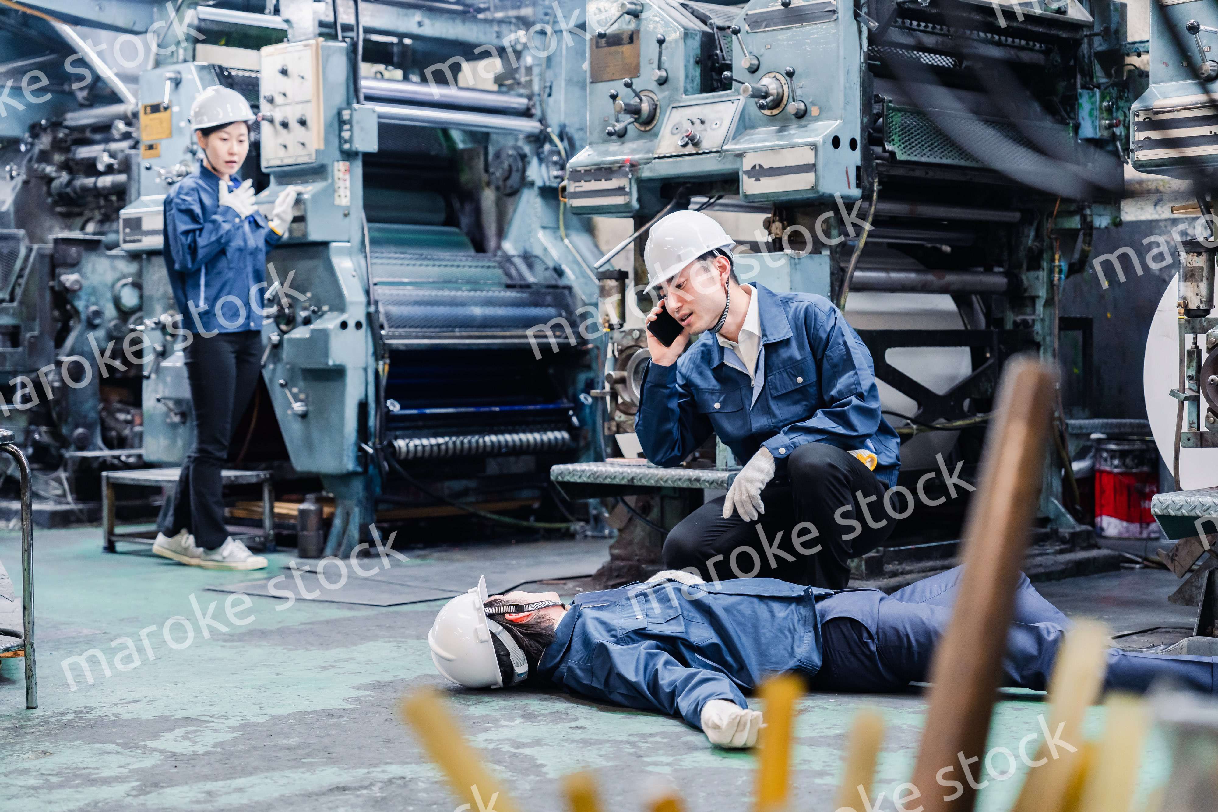 工場で救急通報をする従業員