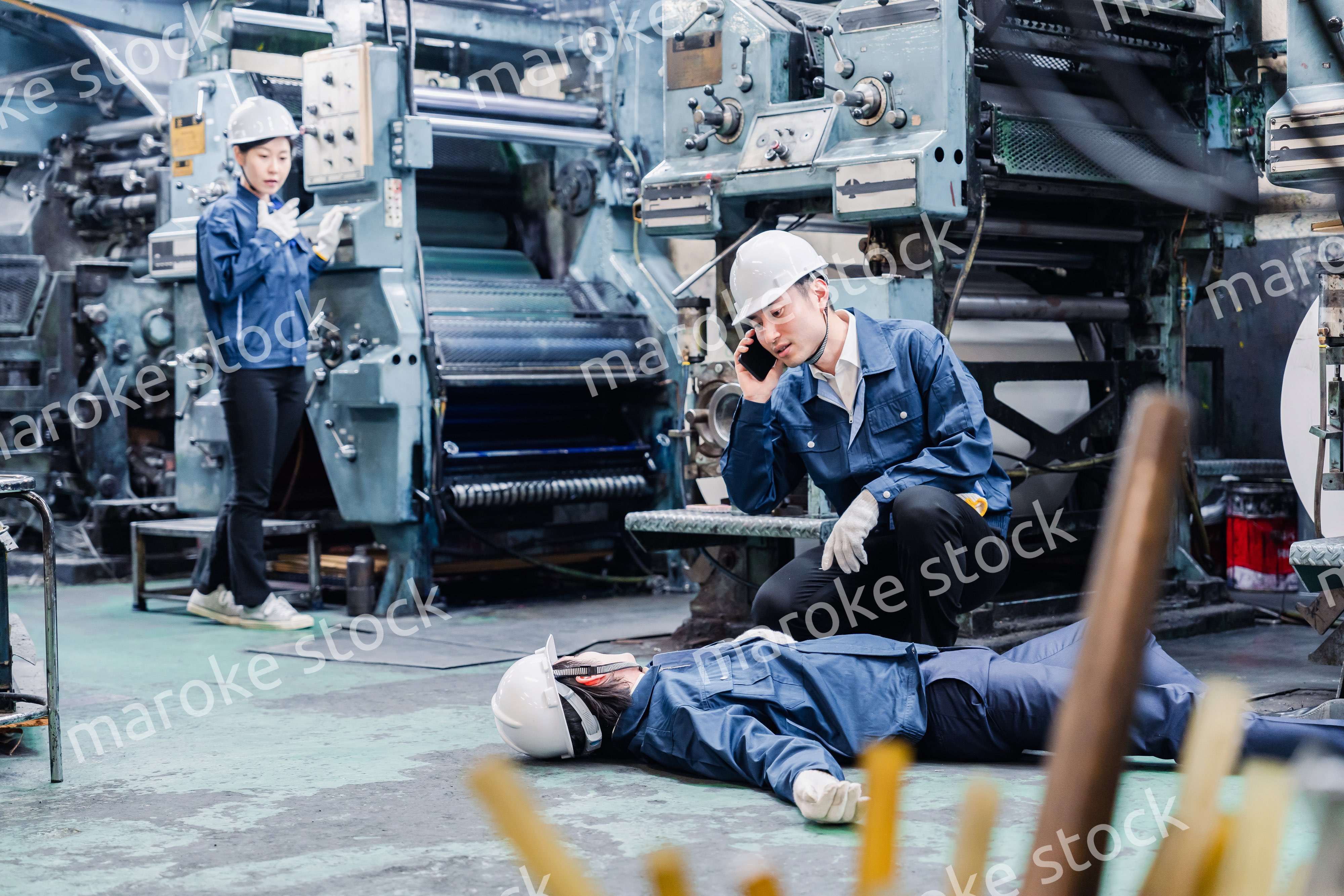 工場で救急通報をする従業員