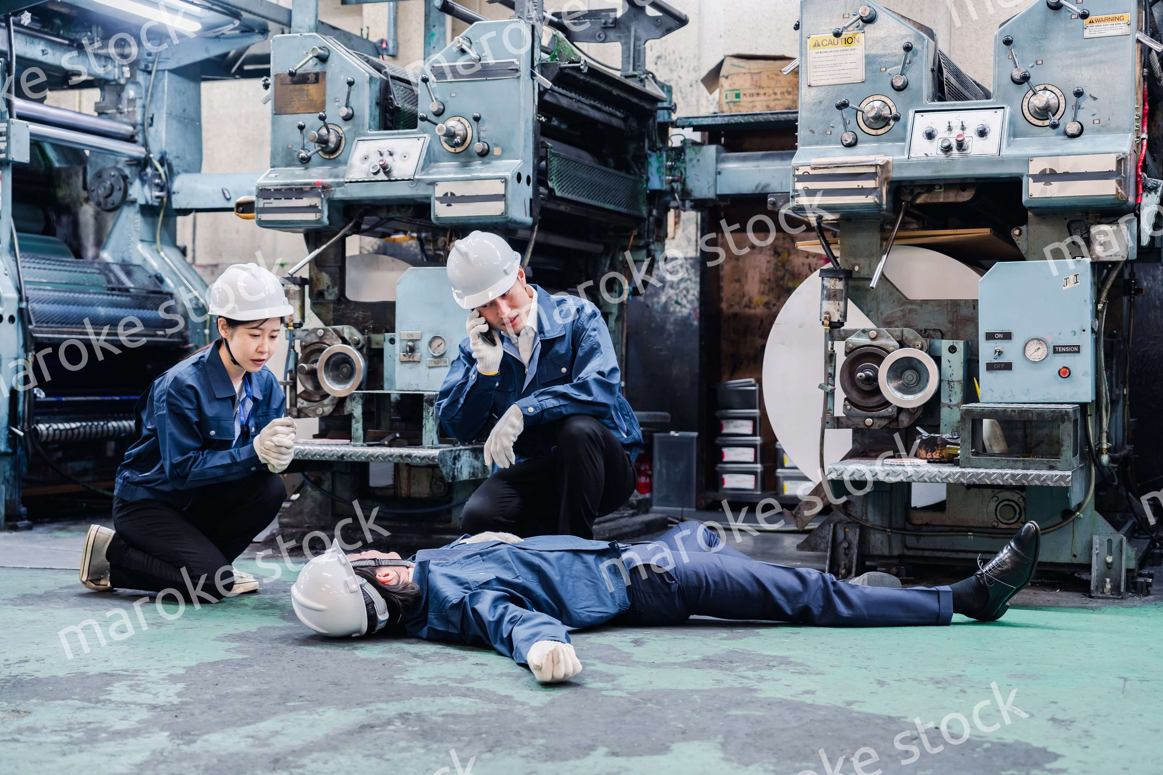 工場で救急通報をする従業員