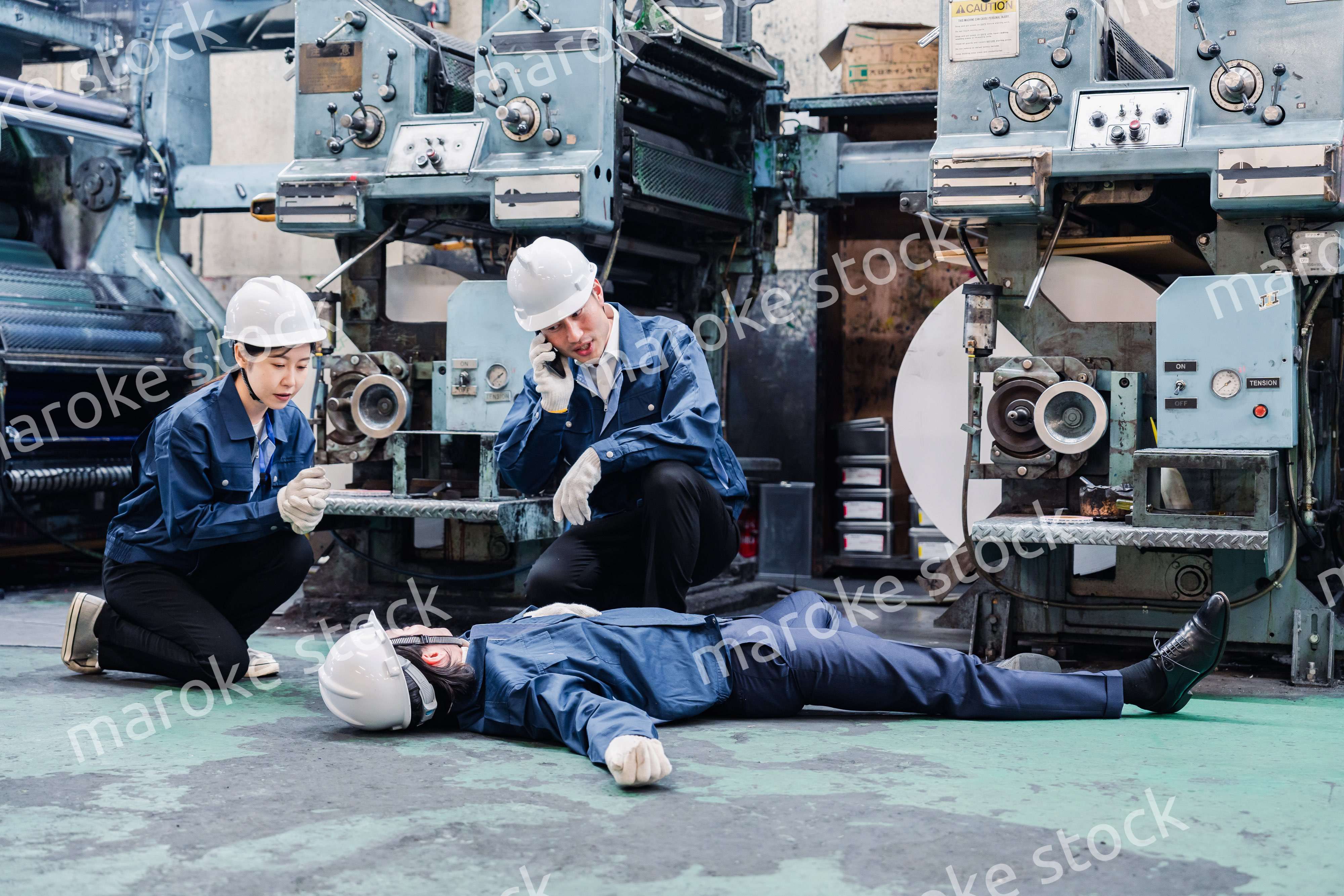 工場で救急通報をする従業員