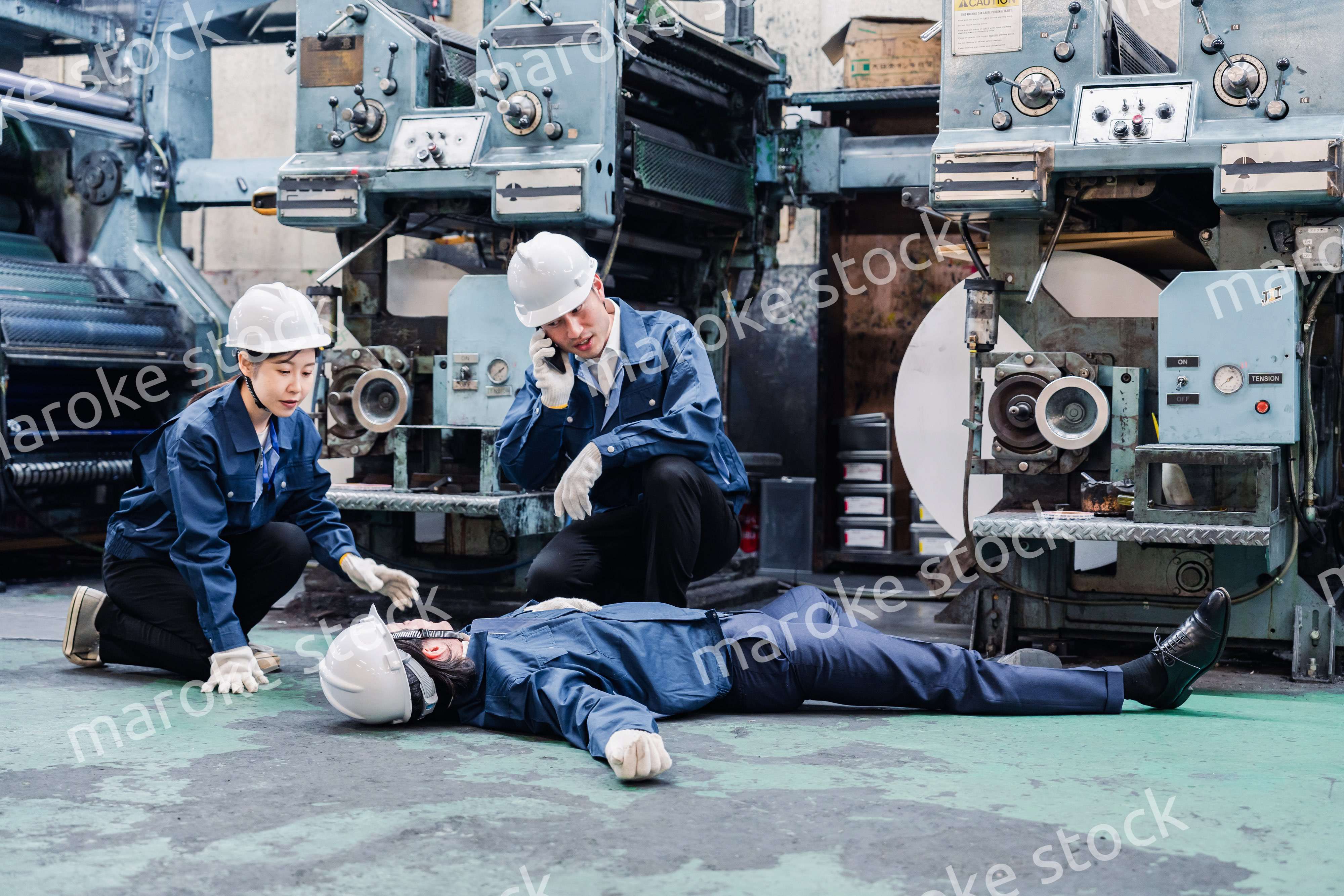 工場で救急通報をする従業員