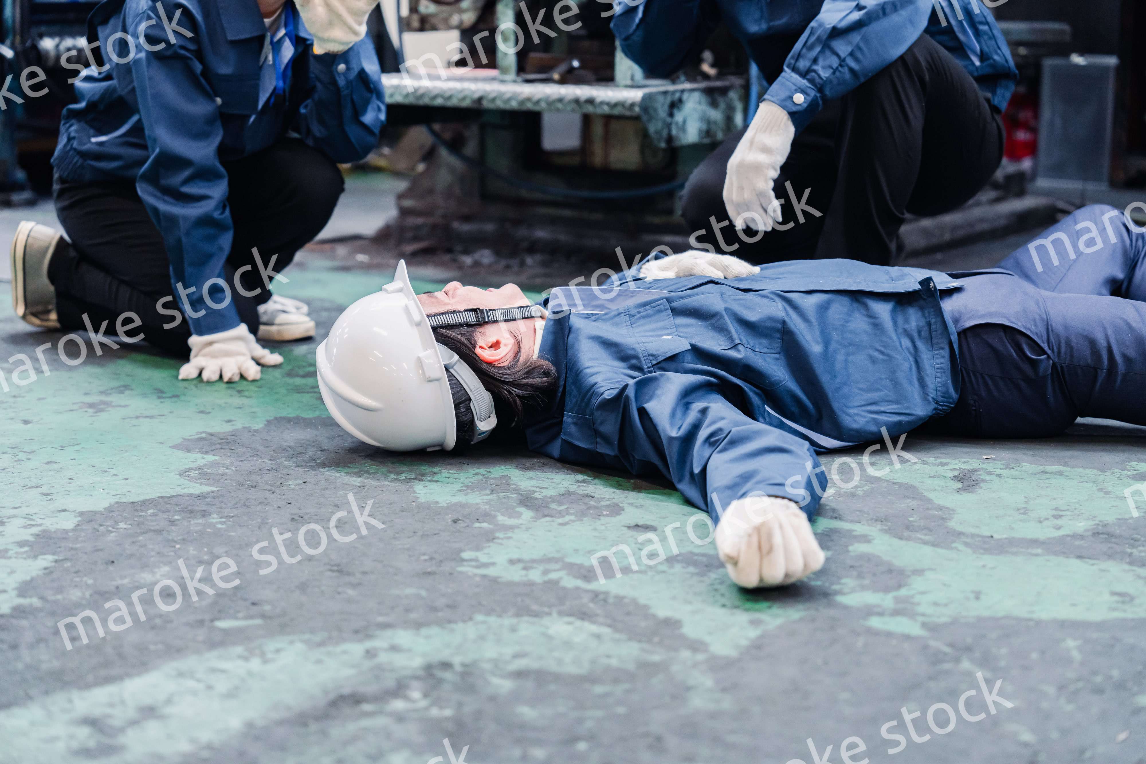 工場で救急通報をする従業員