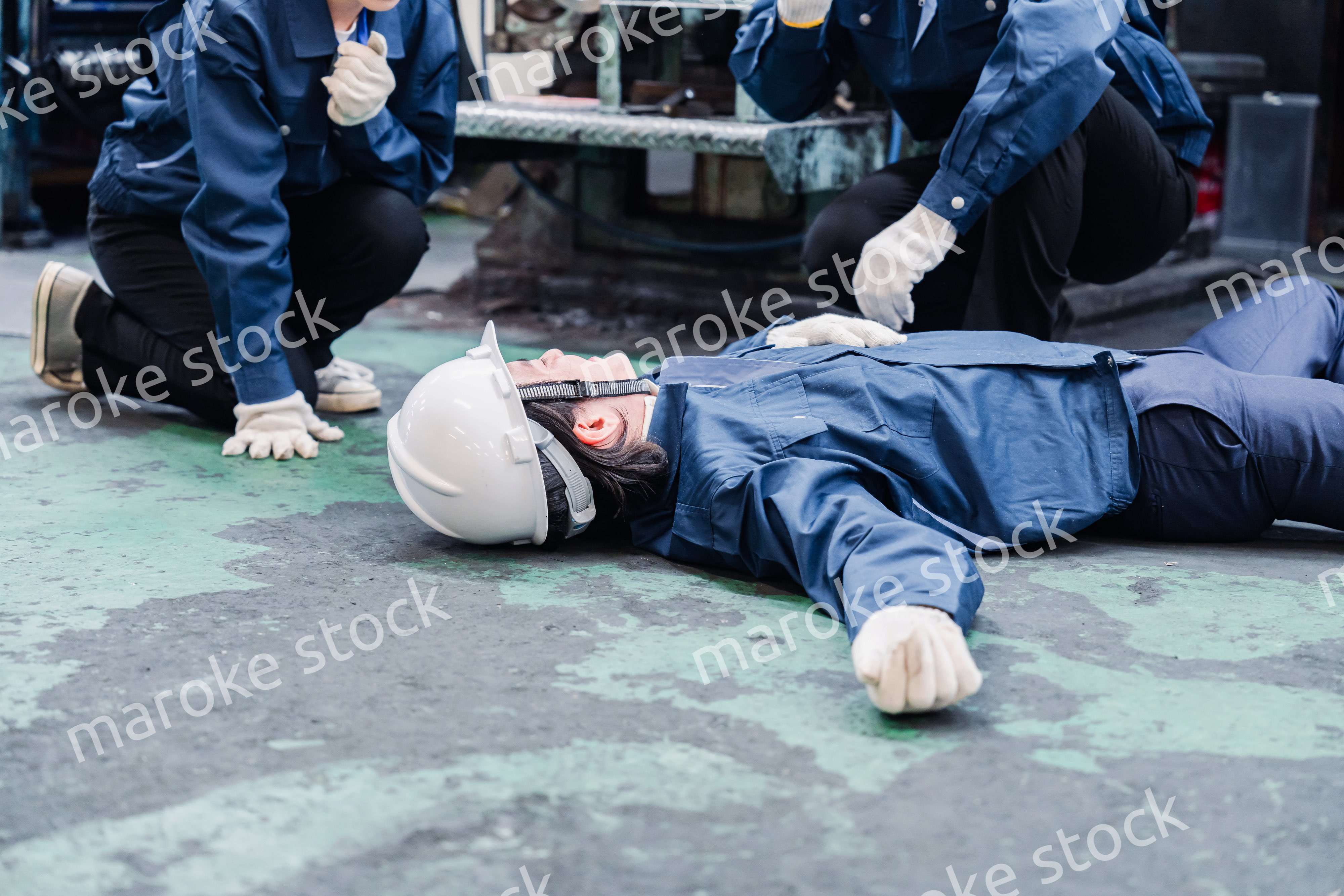 工場で救急通報をする従業員