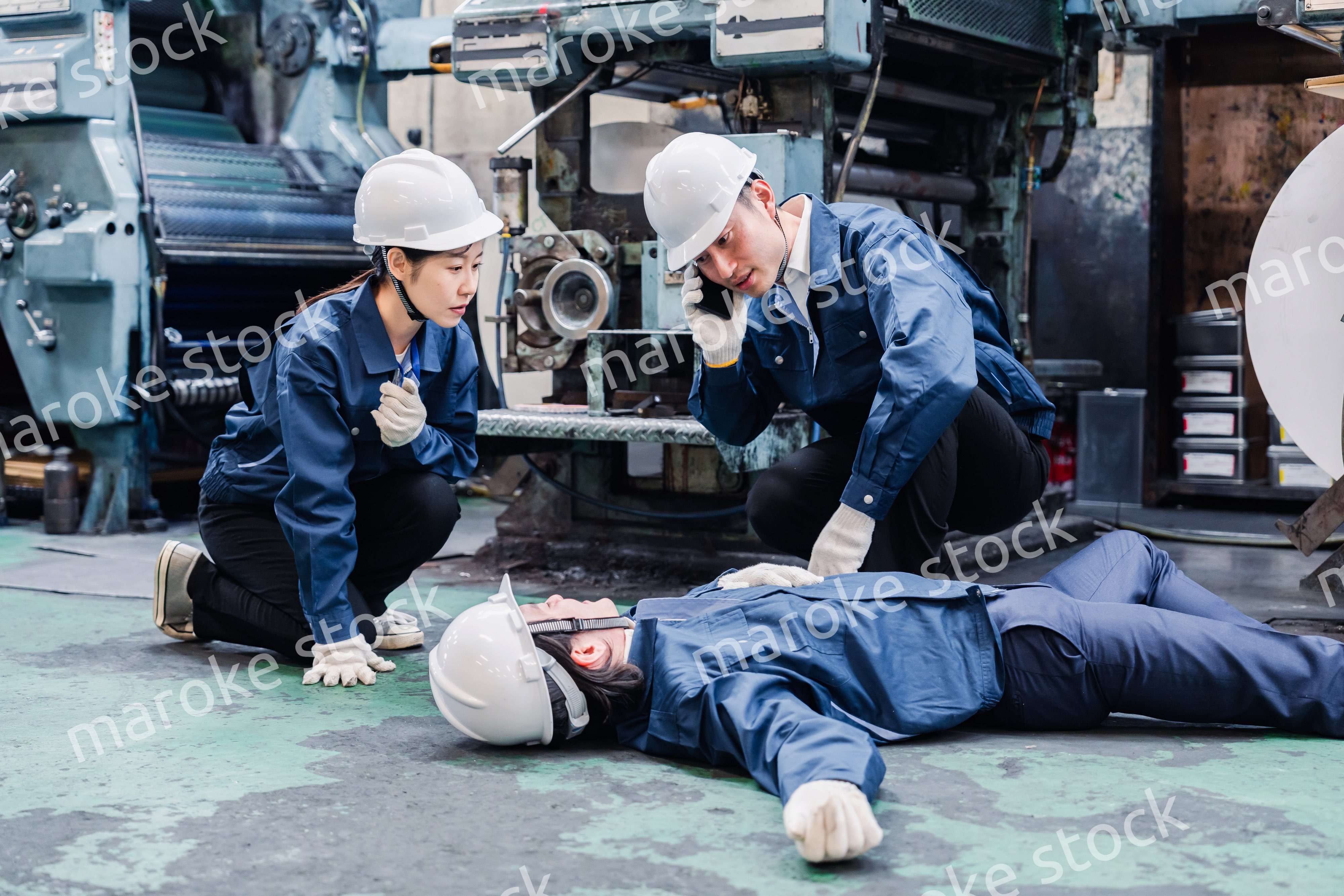 工場で救急通報をする従業員