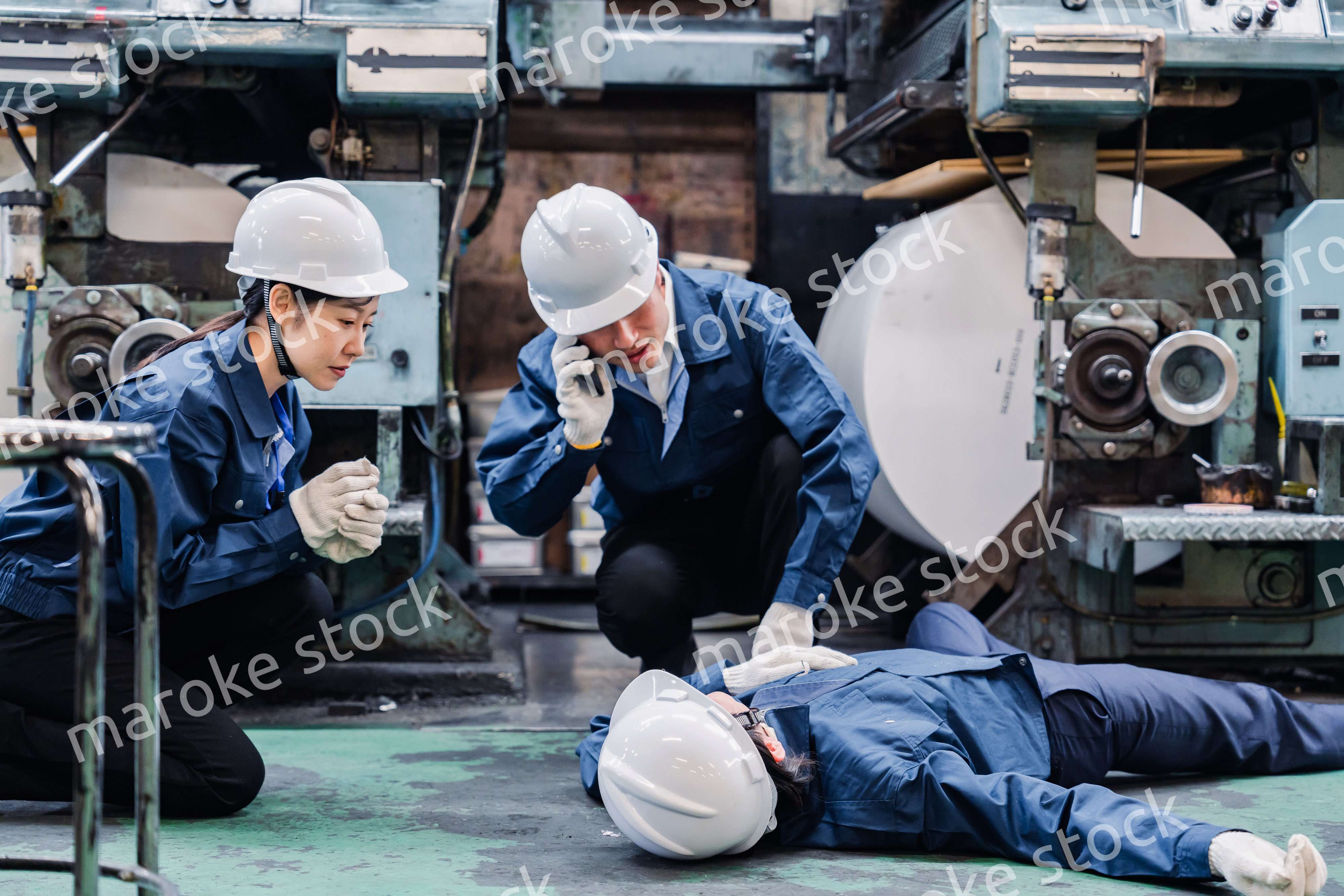 工場で救急通報をする従業員