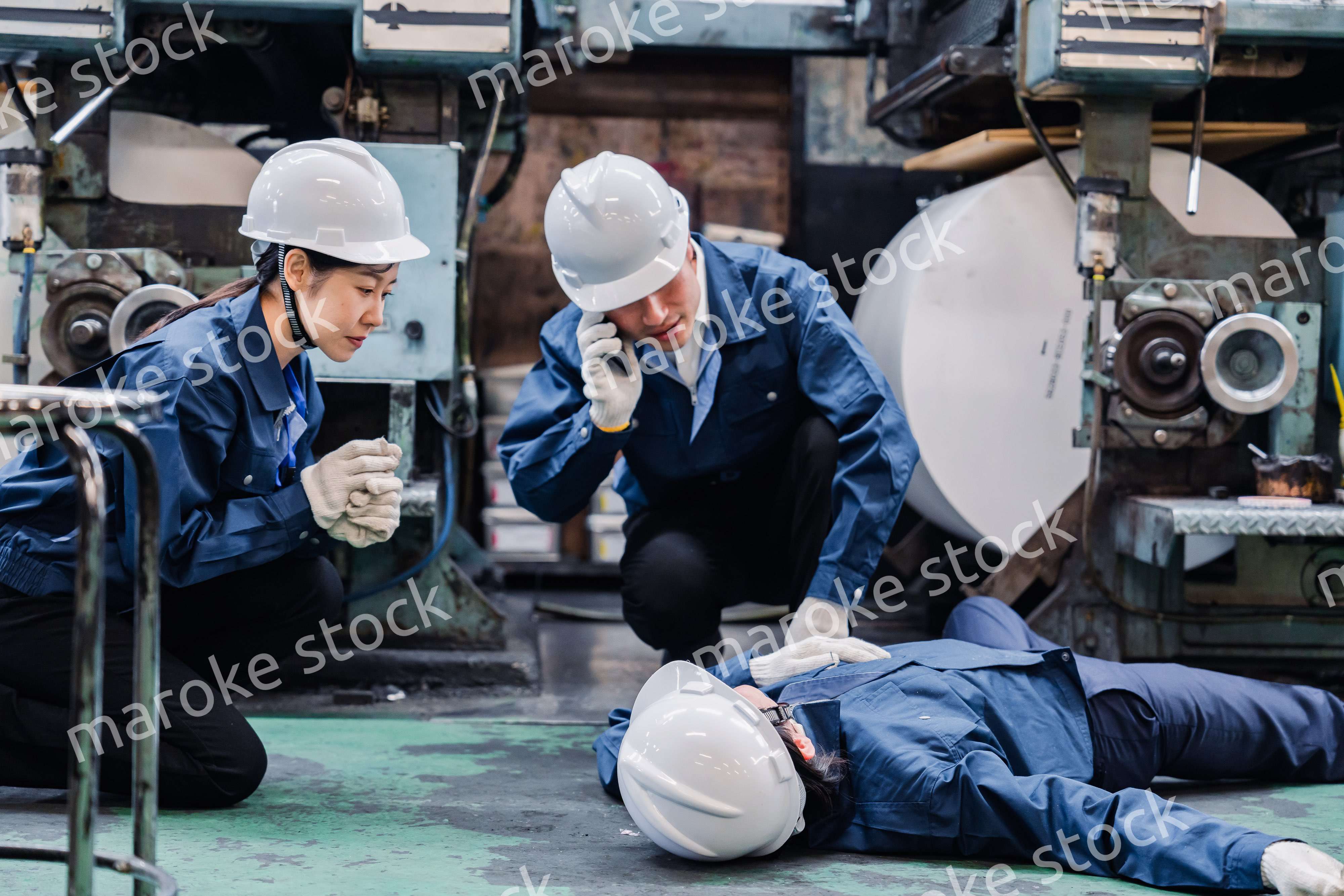 工場で救急通報をする従業員