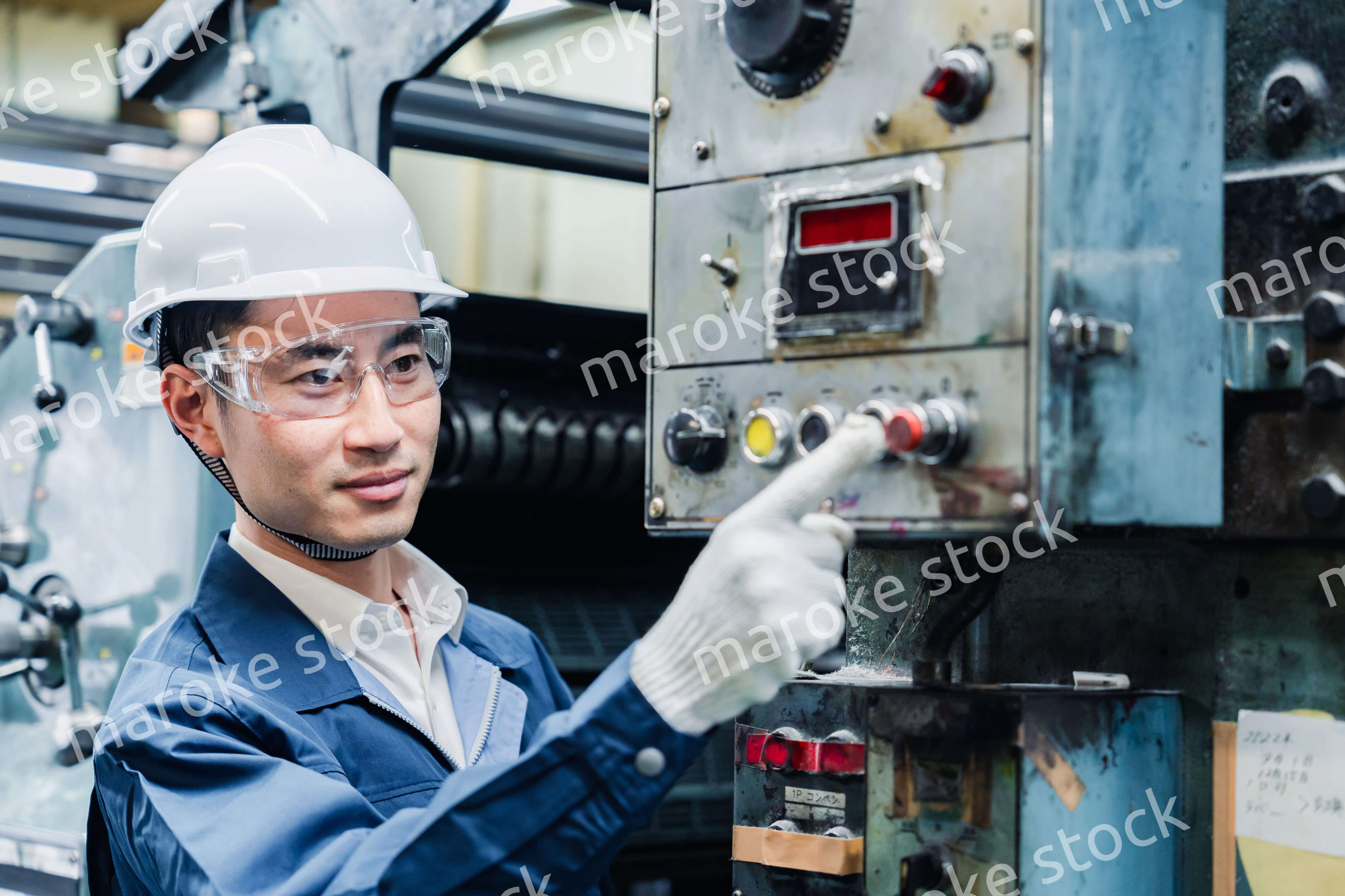 機械のスイッチを入れる男性作業員