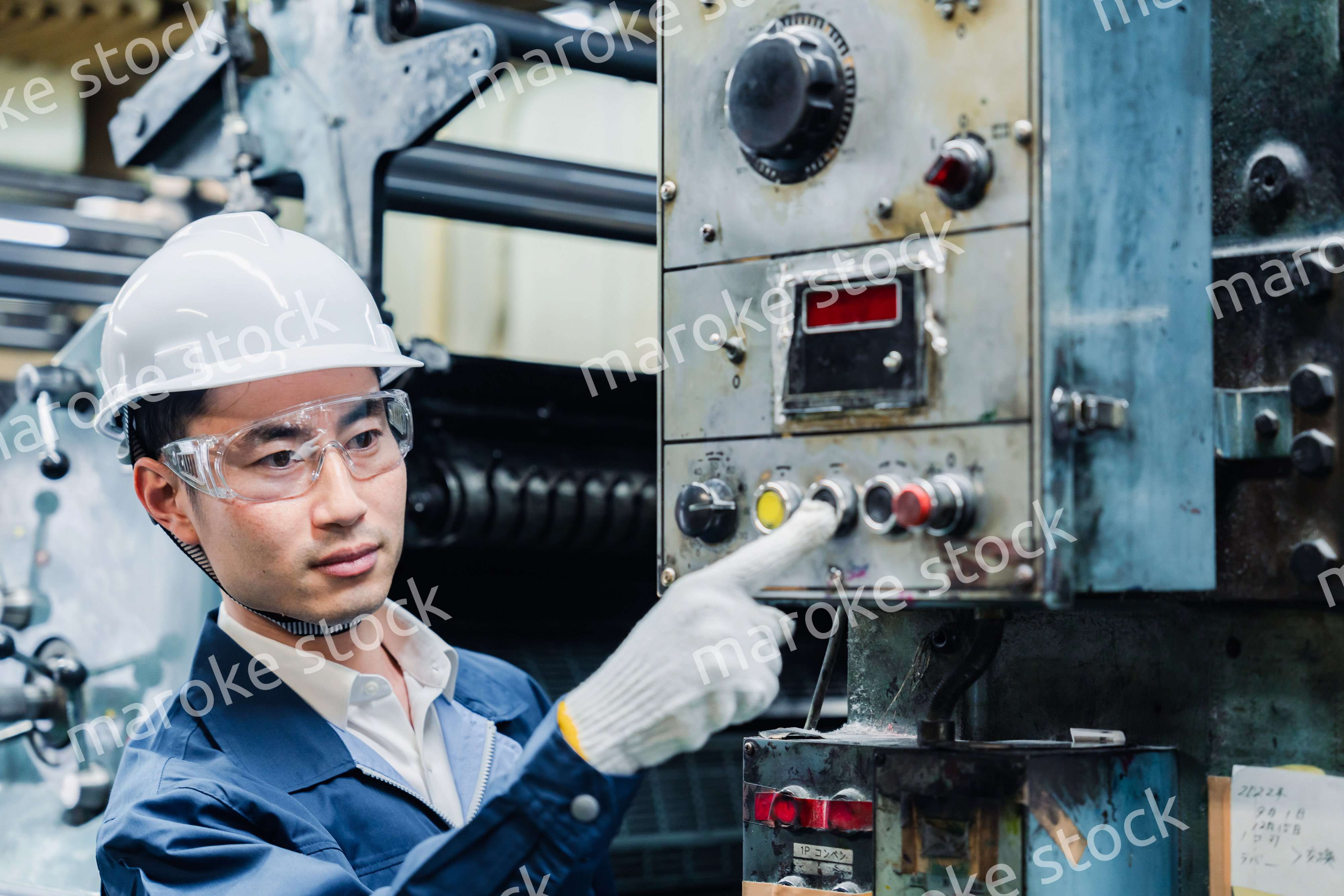 機械のスイッチを入れる男性作業員