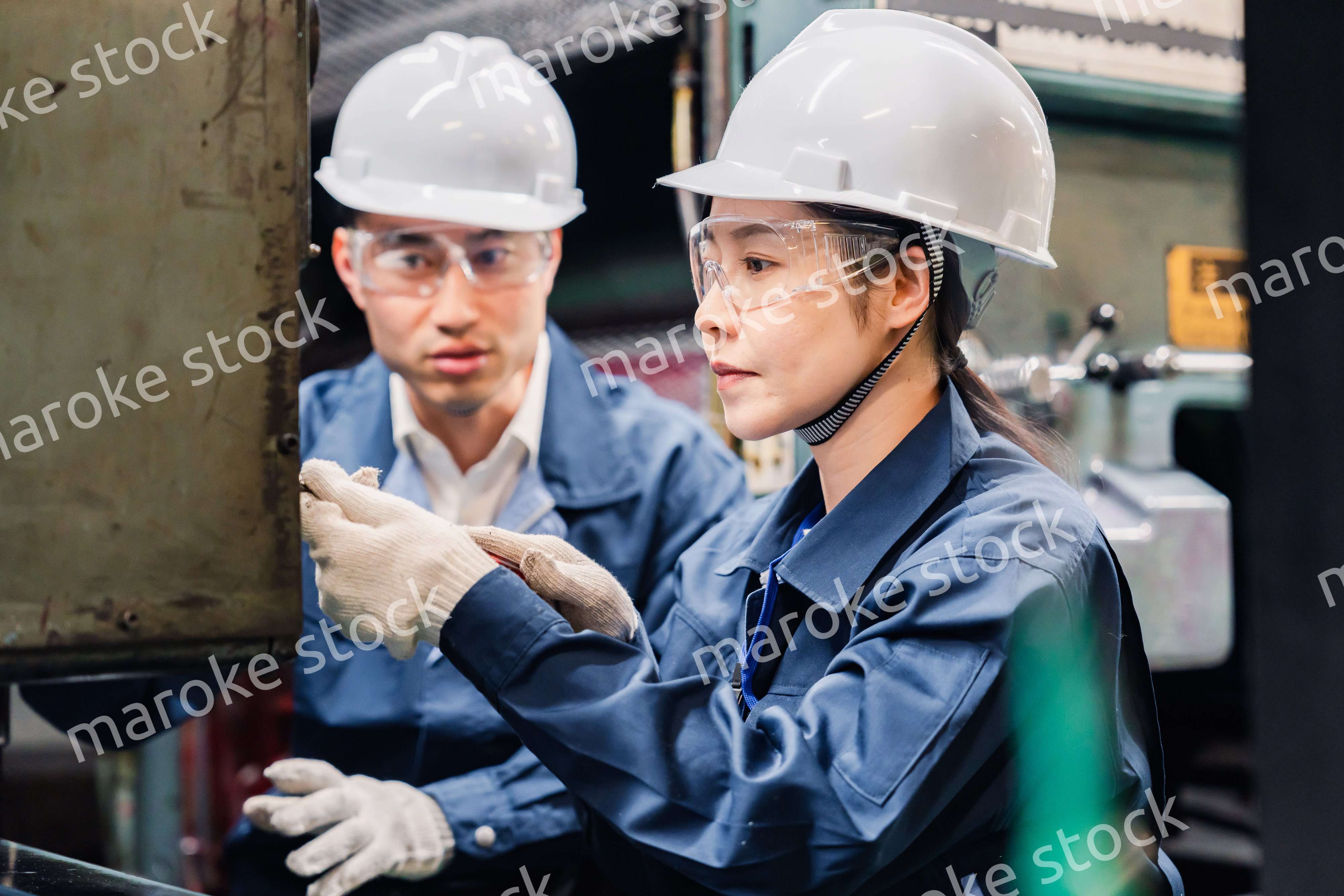 保護メガネを装着して設備の保守点検をする技術者