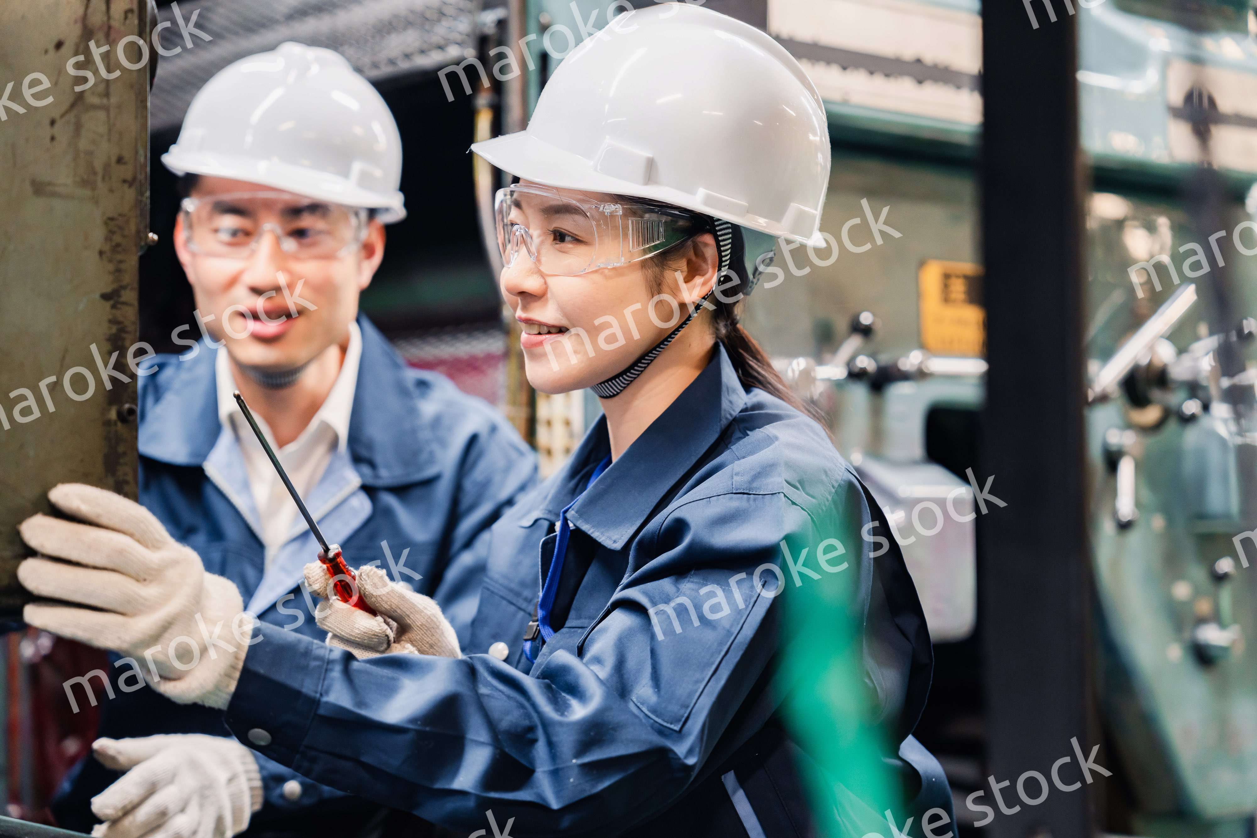 保護メガネを装着して設備の保守点検をする技術者