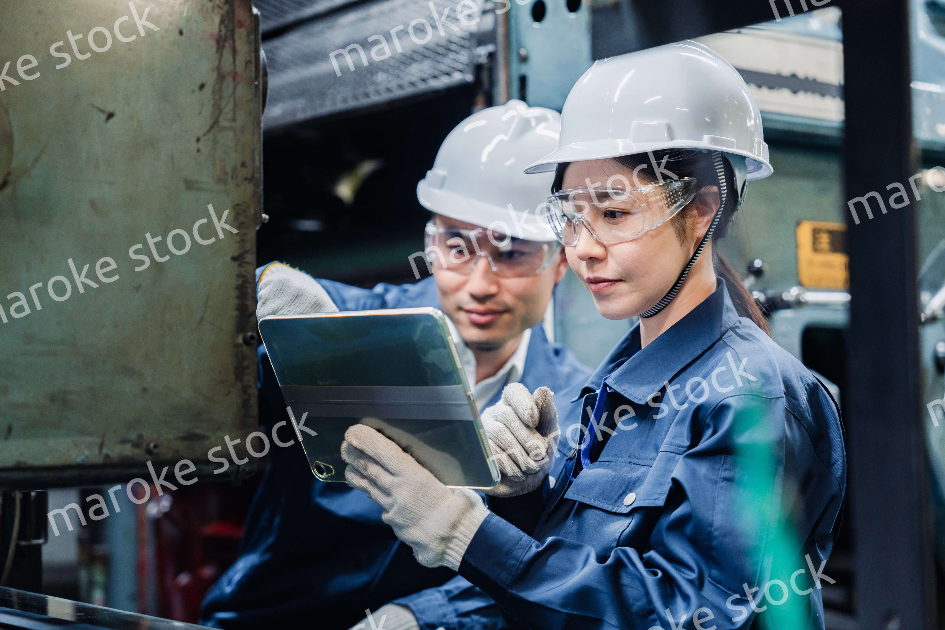 タブレット端末を確認しながら働く技術スタッフ