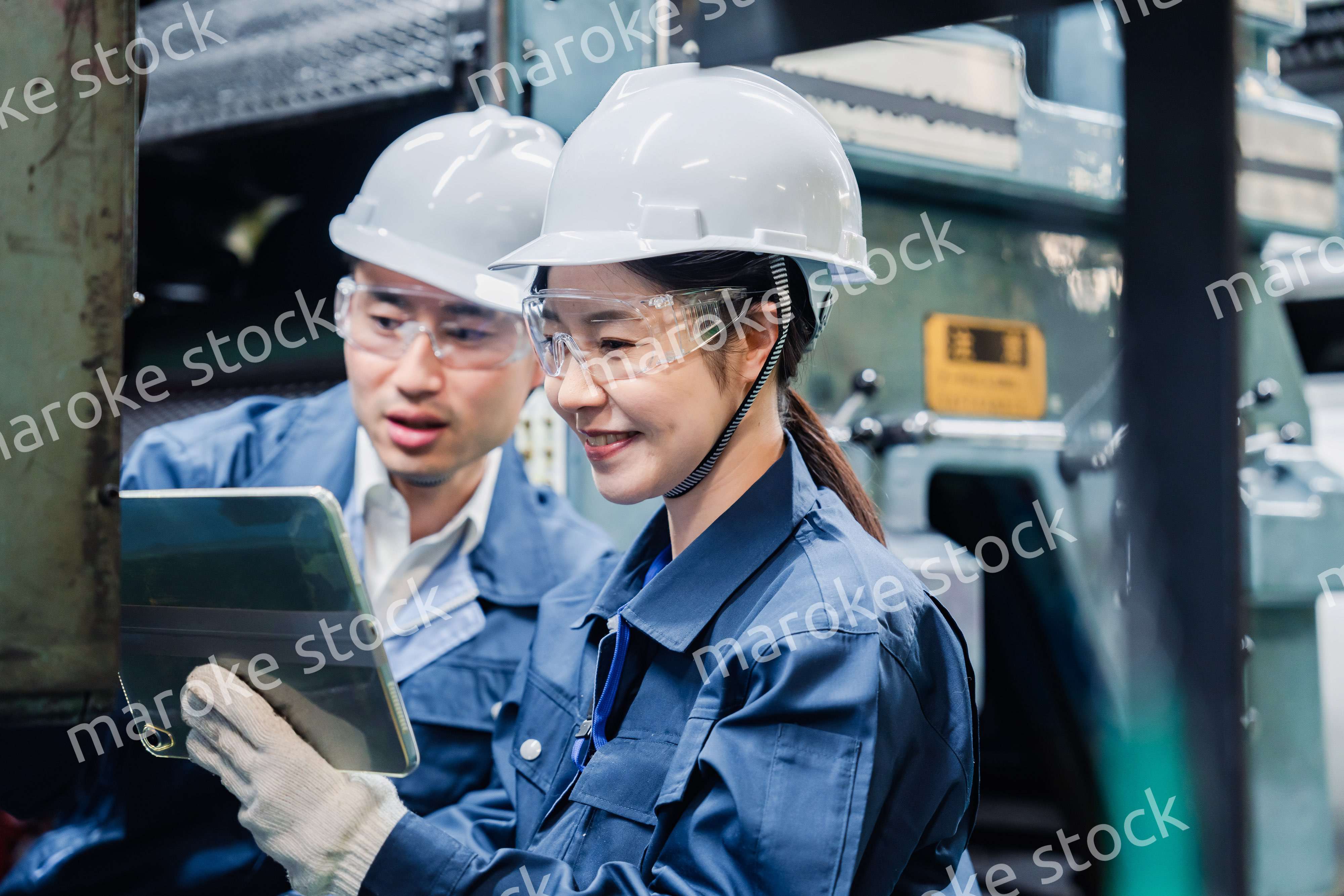 タブレット端末を確認しながら働く技術スタッフ