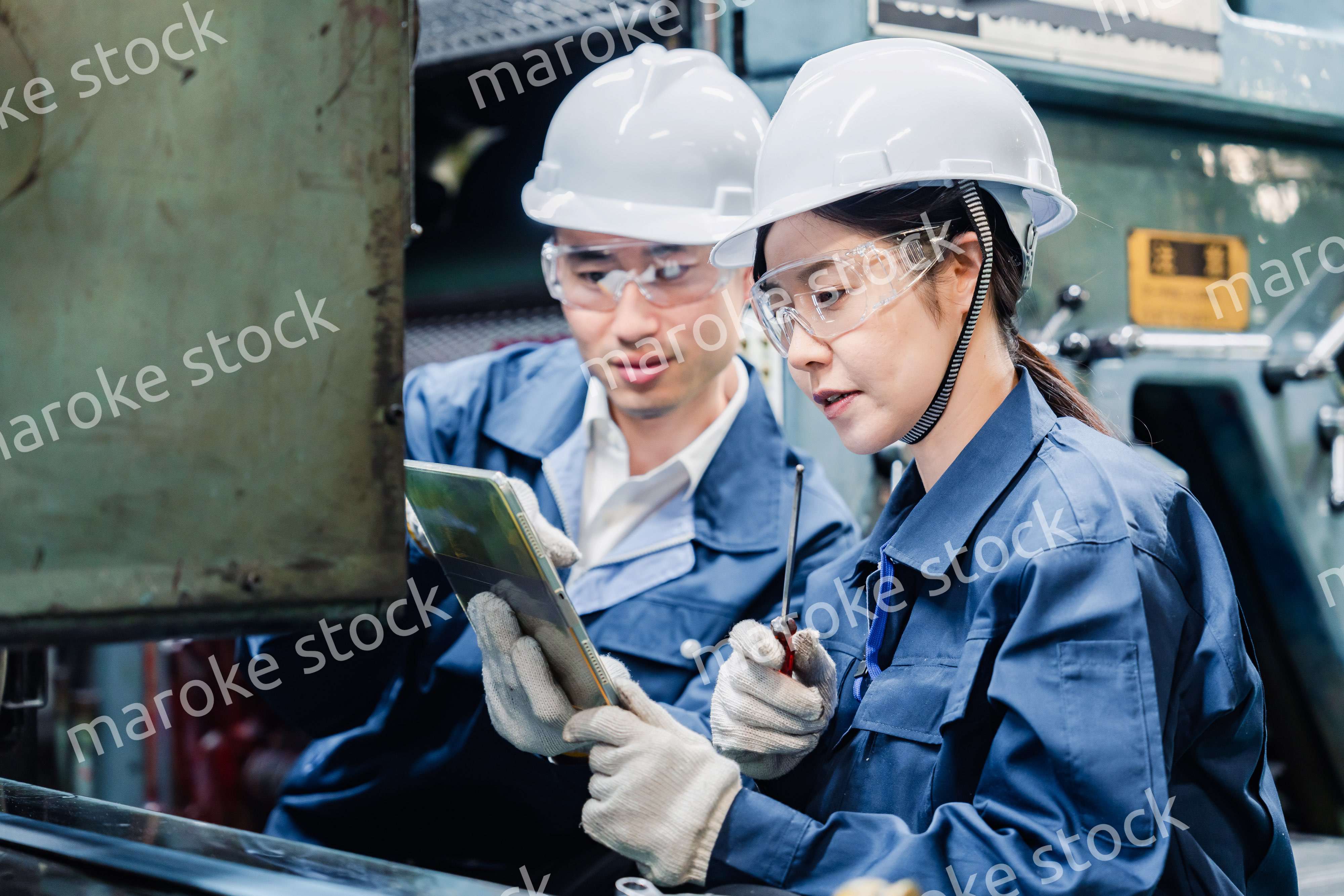 タブレット端末を確認しながら働く技術スタッフ