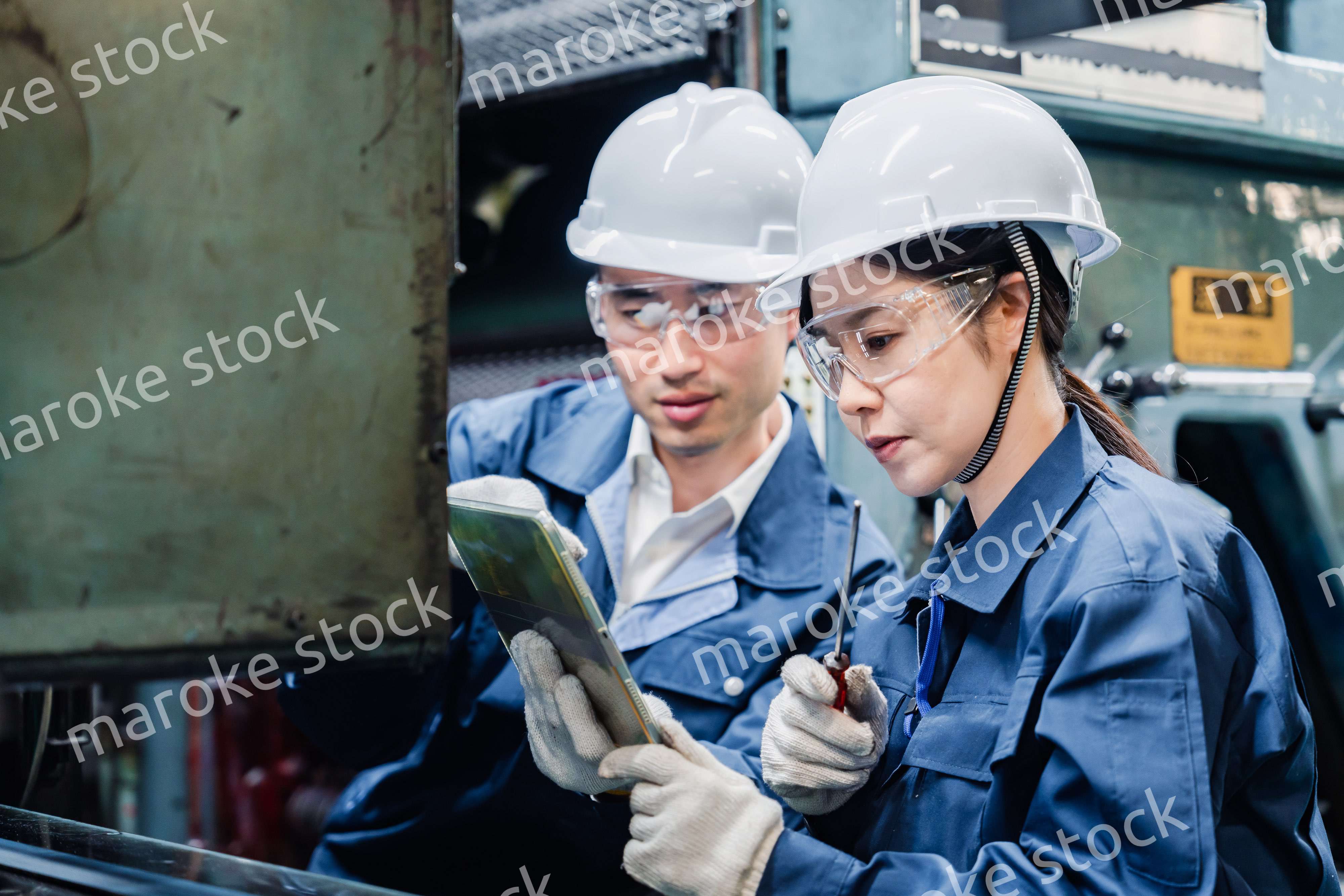 タブレット端末を確認しながら働く技術スタッフ