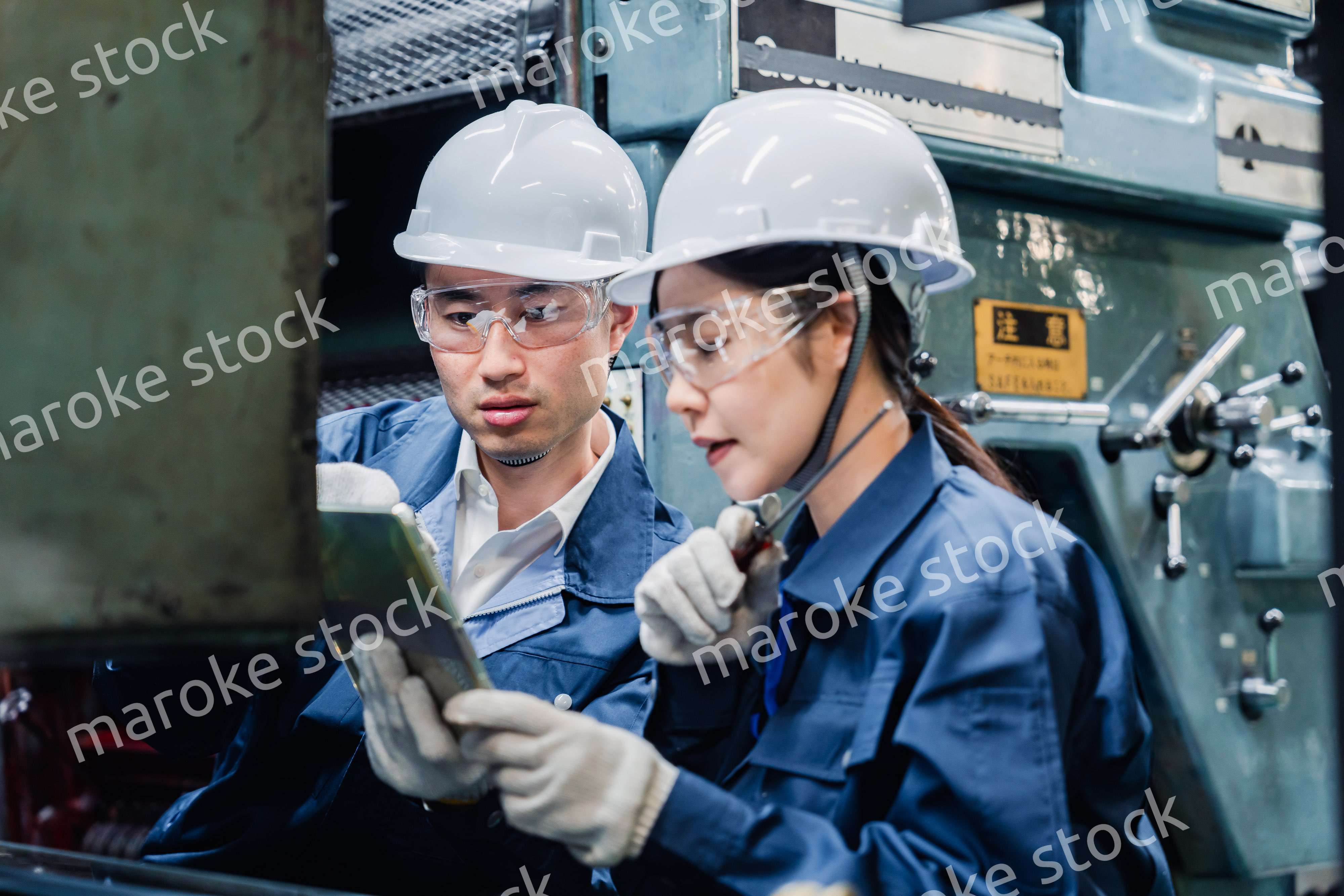 タブレット端末を確認しながら働く技術スタッフ