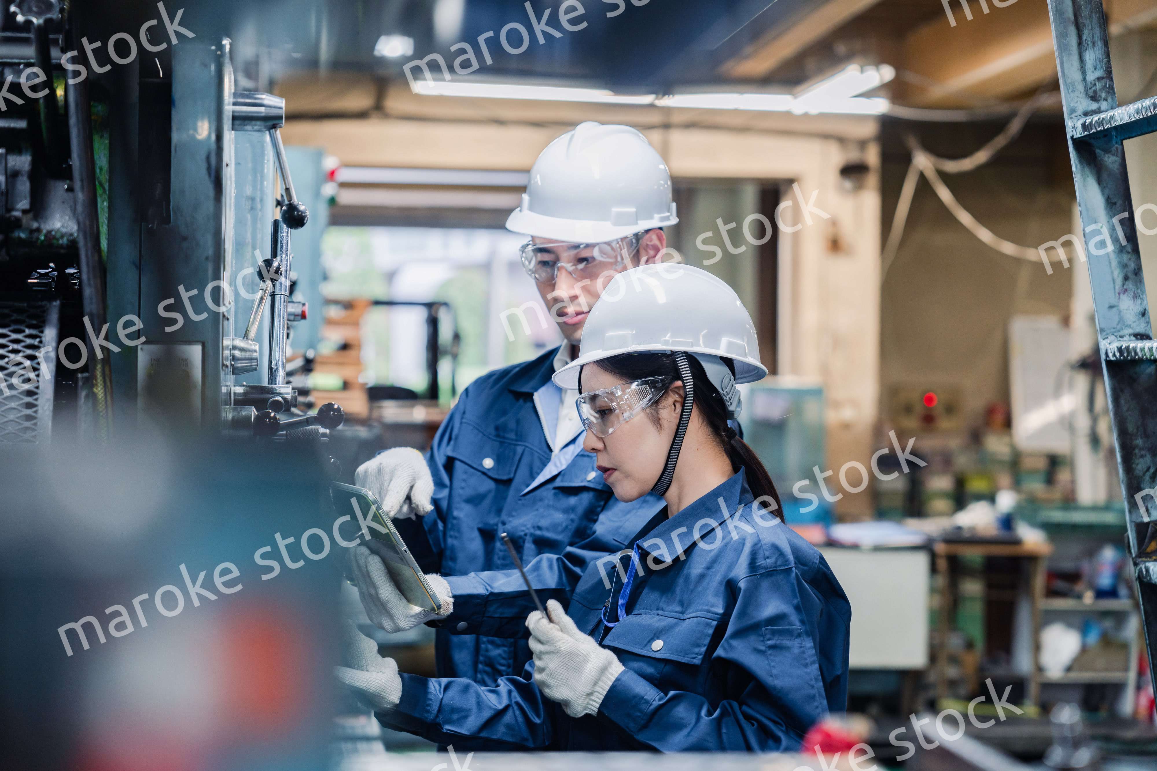 タブレット端末を確認しながら働く技術スタッフ