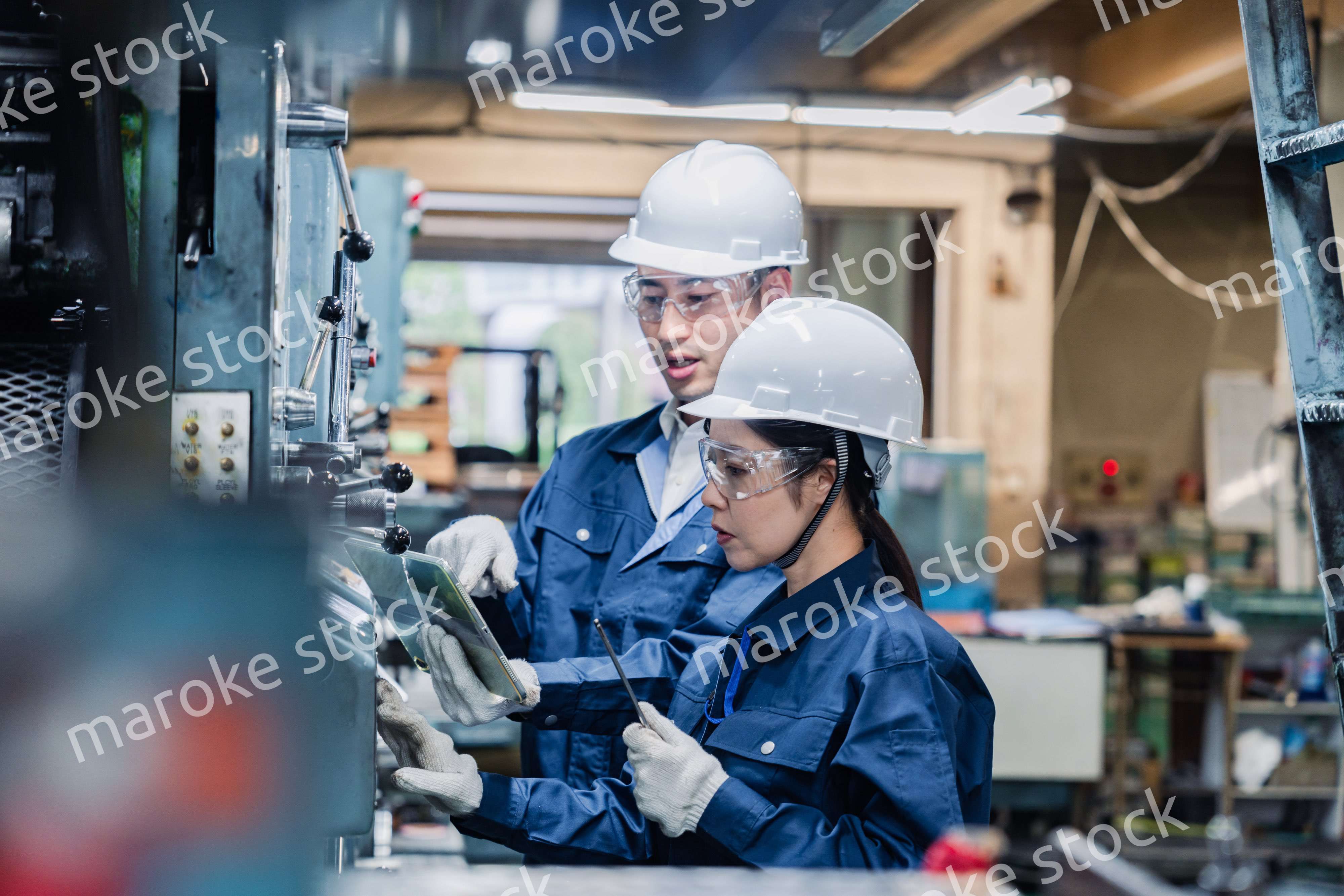 タブレット端末を確認しながら働く技術スタッフ