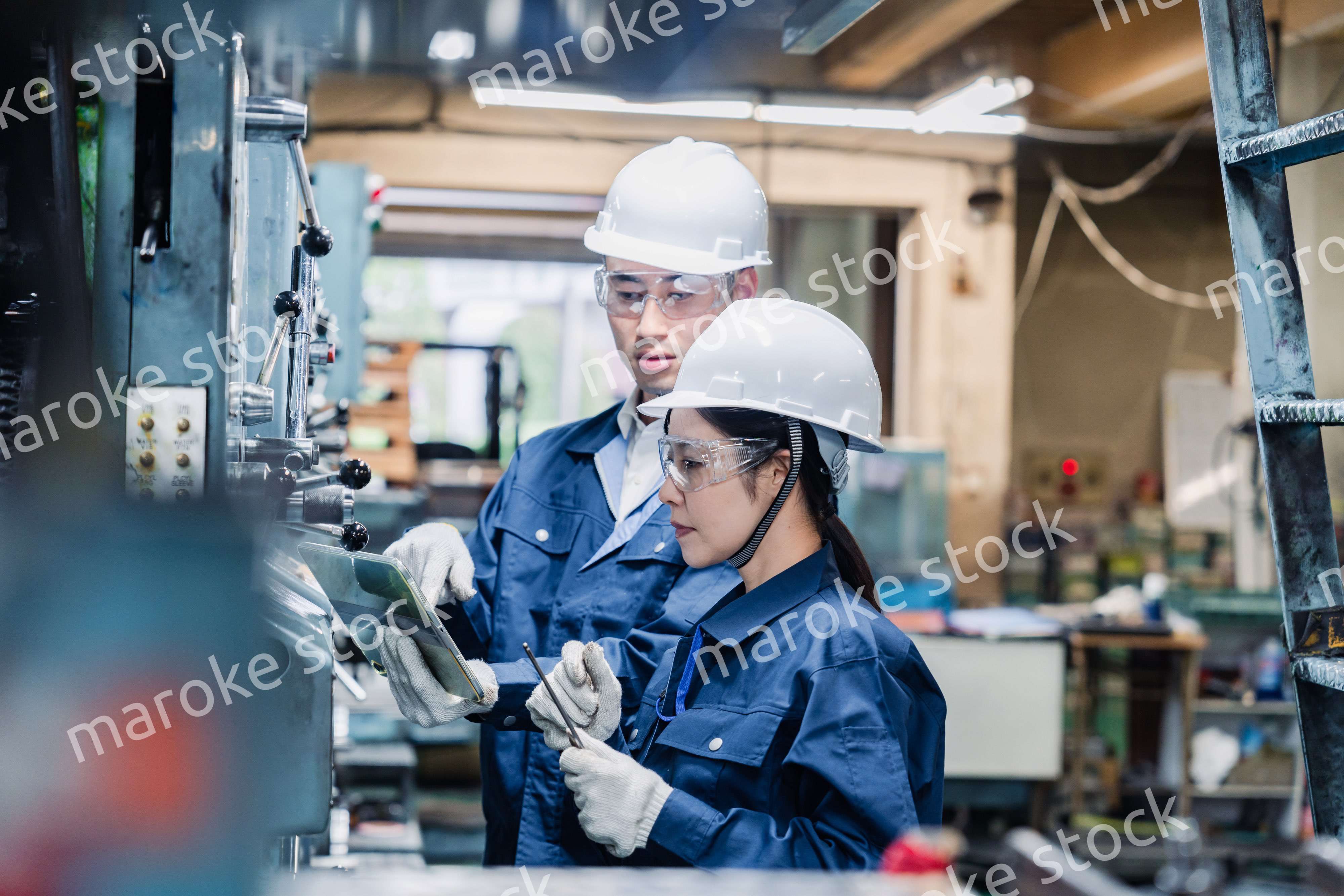 タブレット端末を確認しながら働く技術スタッフ