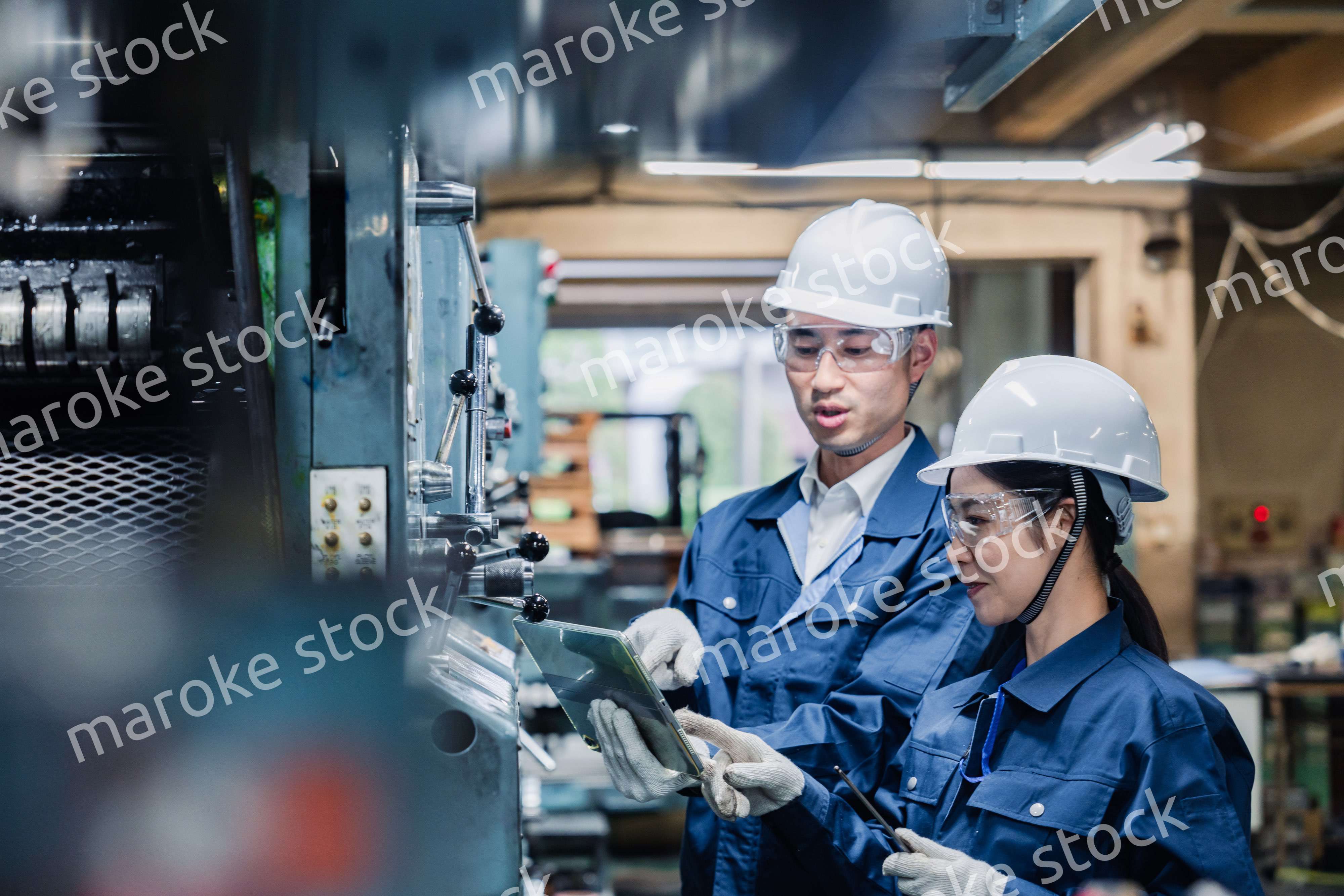 タブレット端末を確認しながら働く技術スタッフ